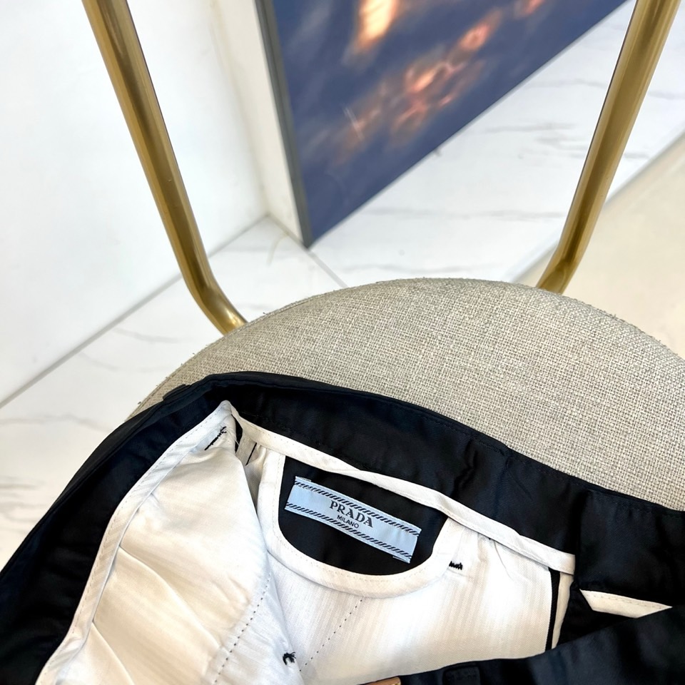 Prad普拉、2025秋冬新品商务休闲长裤。一抹红色，足以定义身份。这条PRADA黑色休闲长裤以极简轮廓