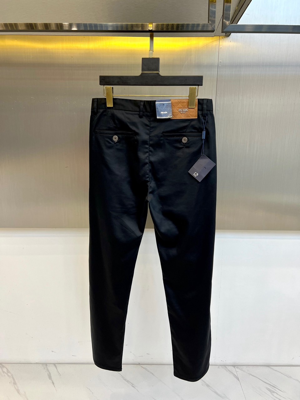 Prad普拉、2025秋冬新品商务休闲长裤。一抹红色，足以定义身份。这条PRADA黑色休闲长裤以极简轮廓