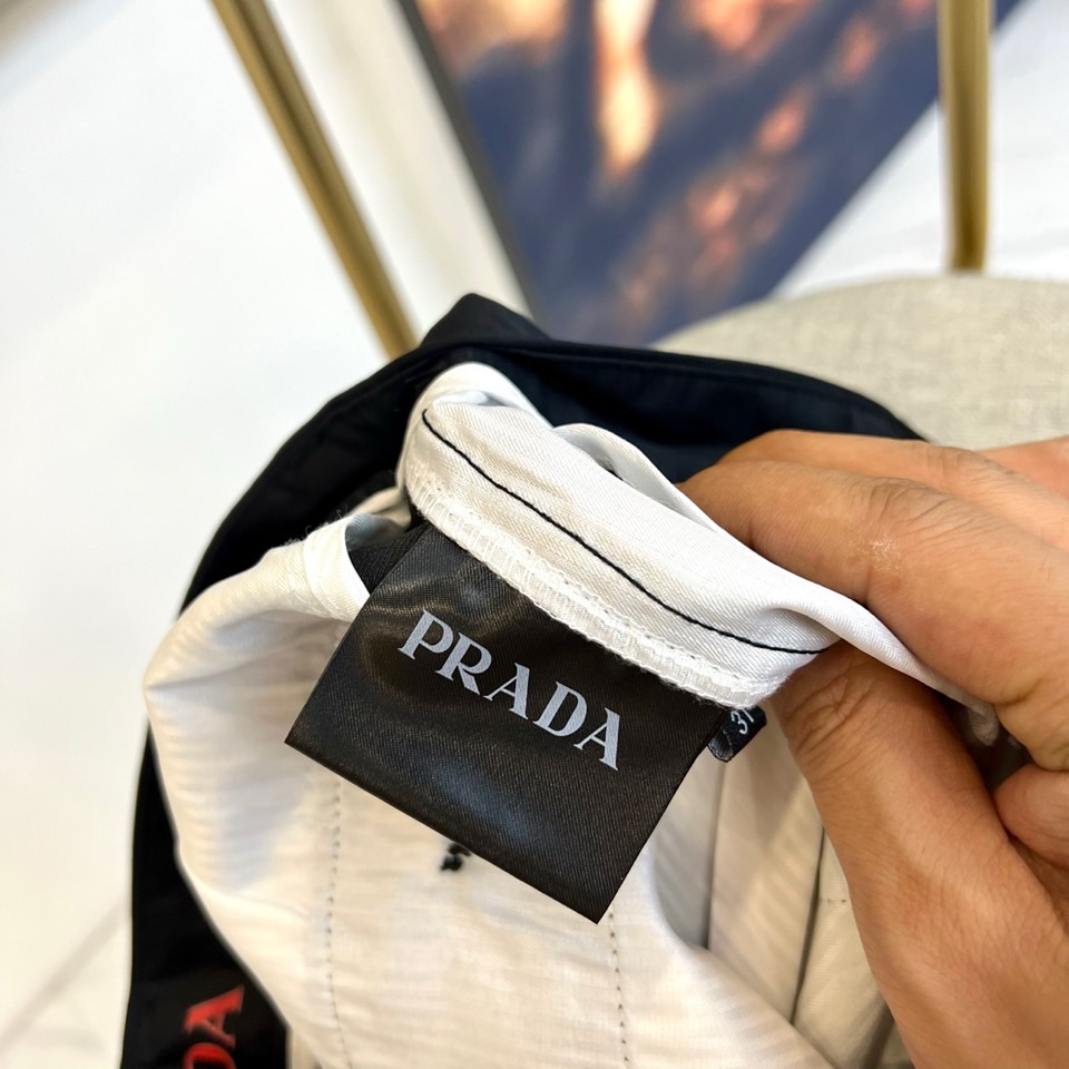 Prad普拉、2025秋冬新品商务休闲长裤。一抹红色，足以定义身份。这条PRADA黑色休闲长裤以极简轮廓