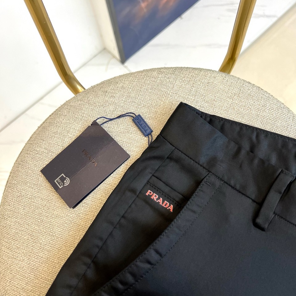 Prad普拉、2025秋冬新品商务休闲长裤。一抹红色，足以定义身份。这条PRADA黑色休闲长裤以极简轮廓