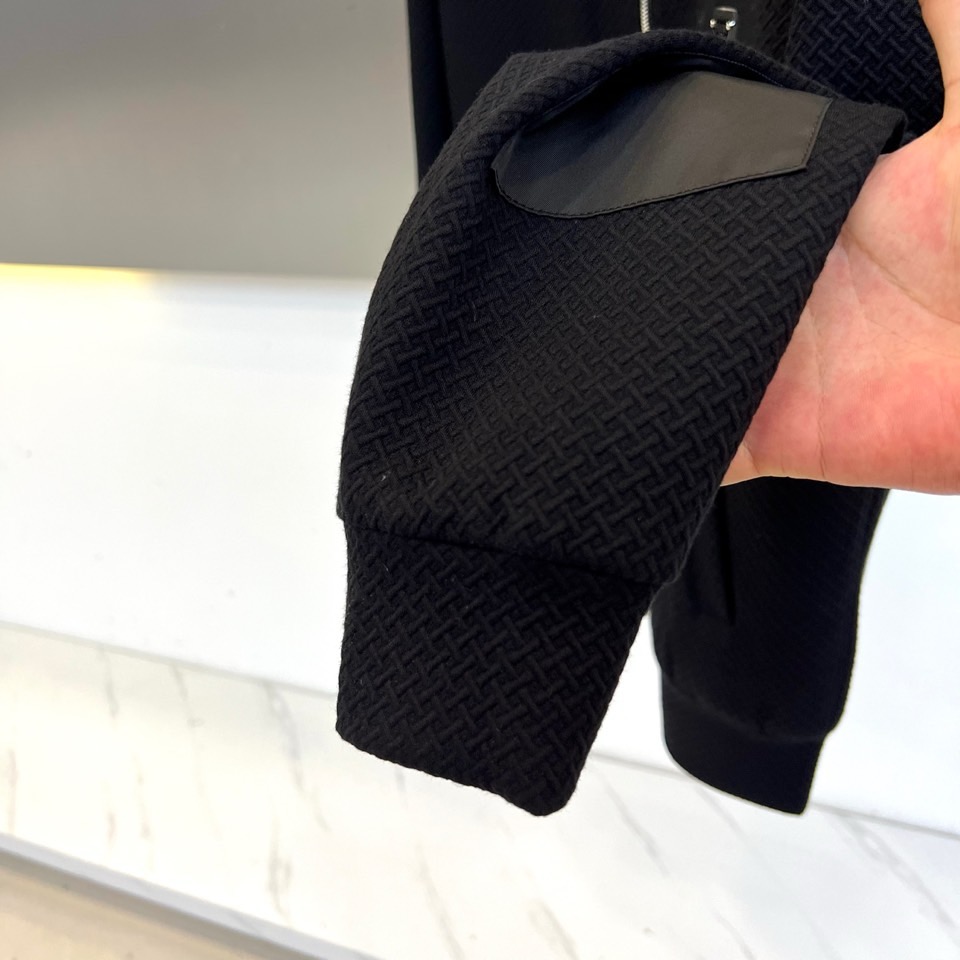 Prad普拉、25FW秋冬新品 黑色针织夹克外套。• 经典徽章加持：左胸翻盖口袋饰以PRADA标志性三角