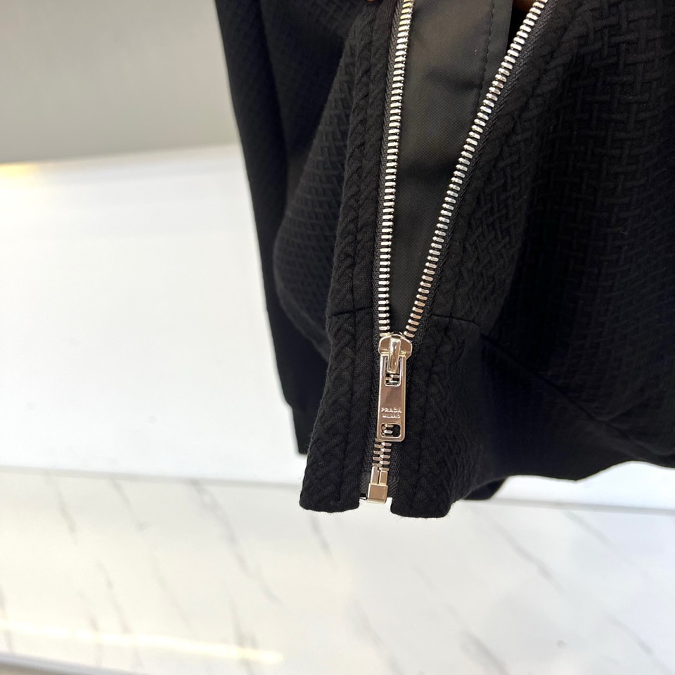 Prad普拉、25FW秋冬新品 黑色针织夹克外套。• 经典徽章加持：左胸翻盖口袋饰以PRADA标志性三角