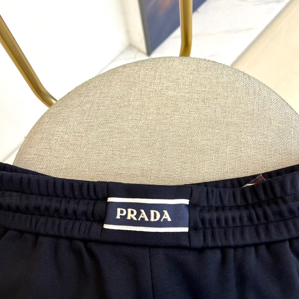 Prad普拉、2025秋冬新品风格休闲裤。这款黑色休闲裤采用PRADA标志性设计，腰头配有抽绳与品牌经典