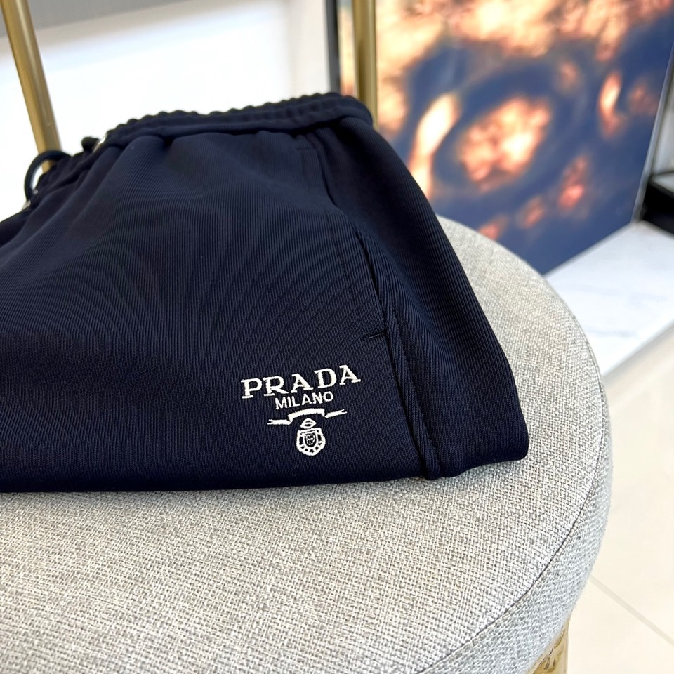 Prad普拉、2025秋冬新品风格休闲裤。这款黑色休闲裤采用PRADA标志性设计，腰头配有抽绳与品牌经典