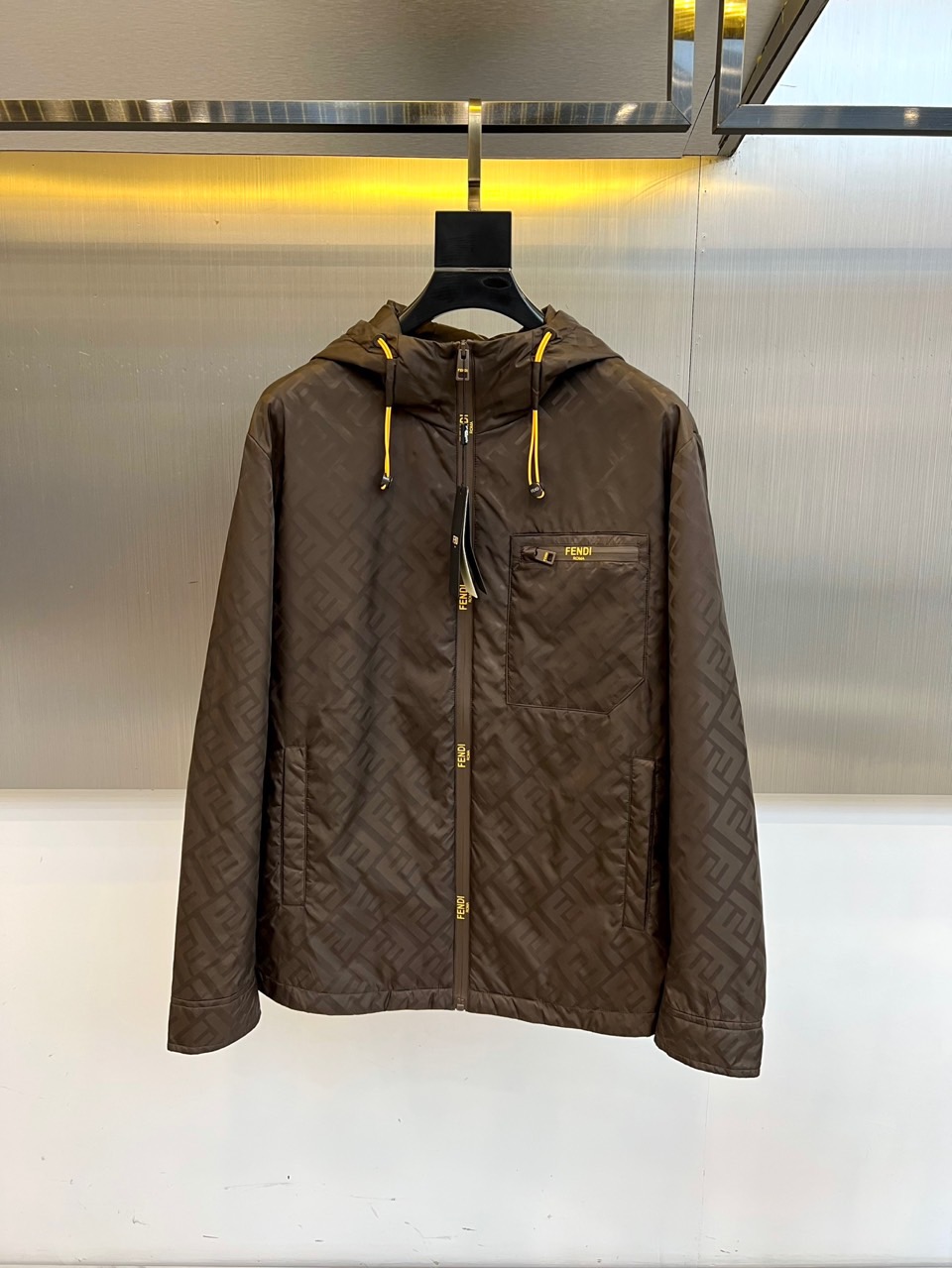 NO:776719,Special price coffee color 50.2 54.2 Special price products are non-refundable and non-exchangeable. The listed price is the actual price.  Fd, the new Fendi jacket for autumn and winter 2025, reshapes the definition of luxury with dark brown FF classic print. It adopts a hooded design with a bright yellow drawstring, which instantly brightens the overall look. The front is opened and closed with a smooth zipper, and the left chest is decorated with a bright yellow FENDI embroidery logo. Each zipper puller is engraved with the brand logo, and the details are full of craftsmanship.  Heart. The fabric is made of high-tech functional materials, which has both windproof and warm performance and light texture. The silhouette is neat and modern, suitable for urban socializing, leisure travel and other occasions. It perfectly integrates practical functions and Italian aesthetics, making it an indispensable iconic item in the autumn and winter wardrobe. 48-56 (model is 173, 143 pounds, upper body size 50)  08,,fendi,fendi,jackets & coats,hats,19860909特价咖色 50.2 54.2 特价产品不退不换 标价即实价 Fd、2025秋冬新品芬迪夹克,以深棕色FF经典印花重塑奢华定义.采用连帽设计搭配亮黄色抽绳,瞬间点亮整体造型.前襟采用顺滑拉链开合,左侧胸前饰有鲜明黄色FENDI刺绣标志,每个拉链头均刻印品牌标识,细节尽显匠心.面料选用高科技机能材质,兼具防风保暖性能与轻盈质感.廓形利落现代,适合都市社交、休闲出行等多种场合,完美融合实用功能与意式美学,成就秋冬衣橱里不可或缺的标志性单品.48-56（模特173,143斤上身50码） 08,,fendi,fendi,jackets & coats,hats,,Men's clothing