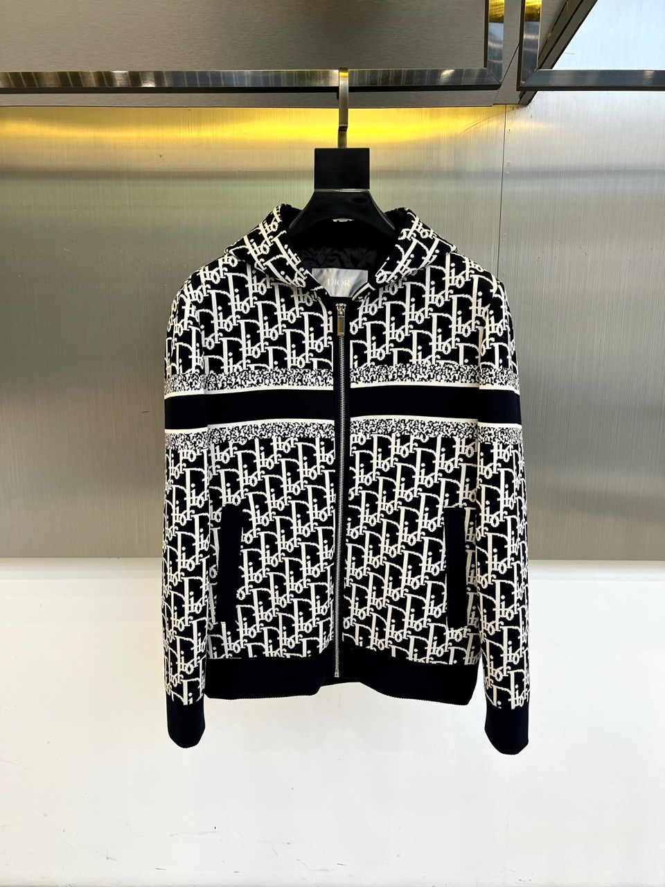 NO:526396,y Dio, the new D-Home Hooded Cotton Clothing Jacket in 2025 autumn and winter, reshapes the classic aesthetics with the brand's iconic Oblique presbyopia pattern. The overall design is made of black and white tones to present the collision of retro and modernity. The hooded design is matched with a smooth center zipper opening and closing, and the cuffs and hem are dark ribbed closing technology to ensure windproof and warmth. The fabric is made of high-tech cotton blend material, with Dior classic twill pattern on the surface, and the left chest is embellished with exquisite brand logo. The lining is made of skin-friendly and dark-textured logo details. Three-dimensional tailoring continues the tradition of Dior precision, with neat and smooth shoulder lines, and the body adopts a moderately loose modern silhouette. It has functional and fashionable presbyopia patterns that highlight the brand's heritage, and the black and white color combinations enhance the freedom of matching. It is suitable for high-end casual, urban travel, social activities and other occasions. It can be matched with simple items to highlight the highlights of the jacket design, or mix and match with formal wear to create a fashionable layering. With Dior's exquisite craftsmanship, classic symbols are integrated into practical outfits, and through the combination of iconic presbyopia patterns and functional design, it has become a must-have item in autumn and winter wardrobe that has both recognition and practical wear. 48-56 (model 173, 143 catties upper body 50 yards),,dior,dior,dior,jackets & coats,hats,alexander wang19860909y Dio迪奥、2025秋冬新品D家连帽棉服夹克,以品牌标志性Oblique老花图案重塑经典美学.整体采用黑白色调呈现复古与现代的碰撞,连帽设计搭配中央顺滑拉链开合,袖口与下摆采用深色罗纹收口工艺,确保防风保暖性能.面料选用高科技棉质混纺材质,表面满印Dior经典斜纹图案,左胸点缀精致品牌标识,内衬采用亲肤材质并印有暗纹Logo细节. 立體剪裁延续迪奥精工传统,肩部线条利落流畅,衣身采用适度宽松的现代廓形.兼具功能性与时尚感老花图案彰显品牌传承,黑白配色提升搭配自由度.适合高端休闲、都市出行、社交活动等多种场合,可搭配简约单品突出夹克设计亮点,或与正装混搭打造时髦层次感.以迪奥精湛工艺将经典符号融入实用着装,通过标志性老花图案与功能性设计的结合,成为秋冬衣橱中兼具辨识度与实穿性的必备单品.48-56（模特173,143斤上身50码）,,dior,dior,dior,jackets & coats,hats,alexander wang,Men's clothing