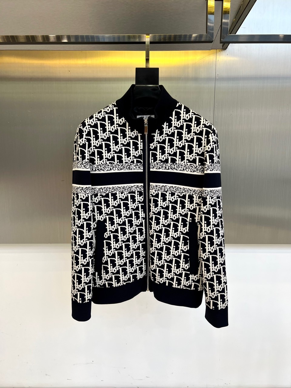 NO:526398,y Dio, 2025 autumn and winter new D home stand-alone cotton jacket, reshapes classic aesthetics with the brand's iconic Oblique presbyterian pattern. The overall design is made of black and white tones to present the collision of retro and modernity. The hooded design is matched with a smooth center zipper closure, and the cuffs and hem are dark ribbed closure to ensure windproof and warmth. The fabric is made of high-tech cotton blend material, with Dior classic twill pattern on the surface, and the left chest is embellished with exquisite brand logo. The lining is made of skin-friendly and dark-print logo details are printed. Three-dimensional tailoring continues the tradition of Dior precision, with neat and smooth shoulder lines, and the body adopts a moderately loose modern silhouette. It has functional and fashionable presbyopia patterns that highlight the brand's heritage, and the black and white color combinations enhance the freedom of matching. It is suitable for high-end casual, urban travel, social activities and other occasions. It can be matched with simple items to highlight the highlights of the jacket design, or mix and match it with formal wear to create a fashionable layering. With Dior's exquisite craftsmanship, classic symbols are integrated into practical outfits, and through the combination of iconic presbyopia patterns and functional design, it has become a must-have item in autumn and winter wardrobe that has both recognition and practical wear. 48-56 (model 173, 143 catties upper body 50 yards),,dior,dior,dior,jackets & coats,hats,alexander wang19860909y Dio迪奥、2025秋冬新品D家立领棉服夹克,以品牌标志性Oblique老花图案重塑经典美学.整体采用黑白色调呈现复古与现代的碰撞,连帽设计搭配中央顺滑拉链开合,袖口与下摆采用深色罗纹收口工艺,确保防风保暖性能.面料选用高科技棉质混纺材质,表面满印Dior经典斜纹图案,左胸点缀精致品牌标识,内衬采用亲肤材质并印有暗纹Logo细节. 立體剪裁延续迪奥精工传统,肩部线条利落流畅,衣身采用适度宽松的现代廓形.兼具功能性与时尚感老花图案彰显品牌传承,黑白配色提升搭配自由度.适合高端休闲、都市出行、社交活动等多种场合,可搭配简约单品突出夹克设计亮点,或与正装混搭打造时髦层次感.以迪奥精湛工艺将经典符号融入实用着装,通过标志性老花图案与功能性设计的结合,成为秋冬衣橱中兼具辨识度与实穿性的必备单品.48-56（模特173,143斤上身50码）,,dior,dior,dior,jackets & coats,hats,alexander wang,Men's clothing