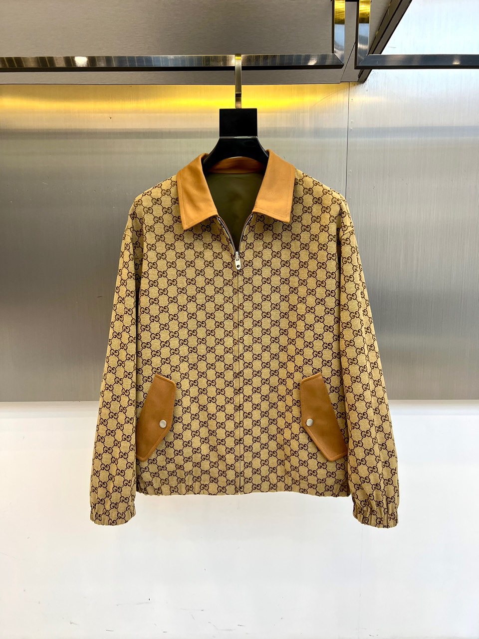 NO:539043,Gucc and Gucci, the new Gucci 2025 autumn and winter new product, reshapes classic fashion with innovative double-sided design. On the one hand, it uses military green glossy material, paired with brown metal zippers and brown leather signs on the left chest, and imprints the GUCCI brand logo to highlight identity; on the other hand, it presents a beige bottom with classic GG printed patterns, and the collar and pocket edges are decorated with brown leather trim, and the details reveal the brand's century-old genes. It uses high-tech functional fabrics, which have wind-proof and water-proof characteristics. The front is equipped with smooth zipper opening and closing, with practical pockets with metal snap buttons on both sides, and the cuffs are elastically closed. The lining hides classic double G pattern, and the hooded design is detachable and convertible, realizing the practical aesthetic of wearing multiple clothes.  Two-sided interpretation of two styles, military green surfaces show the urban functional style, and GG printed surfaces interpret retro and fashionable attitude. Suitable for business and leisure, daily street outings, short trips and other occasions, it can easily achieve the style transformation from low-key simplicity to brand identity. With Italian fine craftsmanship and pragmatic design philosophy, it has become the core item for fashion people's autumn and winter wardrobe. 48-56 (model 173, 143 catties upper body 50 sizes),,gucci,gucci,jackets & coats,hats,alexander wang19860909Gucc古驰、2025秋冬新品Gucci双面穿夹克,以创新双面设计重塑经典时尚.一面采用军绿色光面材质,搭配棕色金属拉链与左胸棕色皮革标牌,压印GUCCI品牌标识彰显身份；另一面呈现米棕色底搭配经典GG印花图案,领口与口袋边缘饰有棕色皮革镶边,细节处流露品牌百年基因. 采用高科技功能性面料,具备防风防泼水特性.正面配备顺滑拉链开合,两侧设带金属按扣的实用口袋,袖口采用弹性收口设计.内衬暗藏经典双G图案,连帽设计可拆卸转换,实现一衣多穿的实用美学. 双面演绎两种风格军绿色面展现都市机能风范,GG印花面诠释复古时髦态度.适合商务休闲、日常出街、短途旅行等多种场合,轻松实现从低调简约到品牌标识化的风格转换.以意大利精工技艺与实用主义设计哲学,成为时尚人士秋冬衣橱的核心单品.48-56（模特173,143斤上身50码）,,gucci,gucci,jackets & coats,hats,alexander wang,Men's clothing