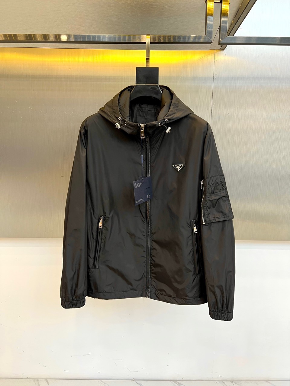 NO:539048,Prad, black functional jacket | Dark Night Straight, defines the contemporary style. The iconic triangle badge is decorated with a polished silver metal logo on the left chest, continuing the century-old gene of Prada, and reveals an identity symbol in the dark tone. The multi-functional pocket system has a double-sided oblique zipper pocket + left sleeve hidden patch pocket, taking into account practicality and smooth contour, and carving the personal objects without any trace. The details are adjustable, drawstring hooded with metal buckles, and the lining is made of dark gray skin-friendly fabric to improve wear comfort; the front matte zipper is neatly opened and closed, echoing the futuristic functional aesthetics. 48-56 (model 173, 143 catties upper body 50 yards),, prada, prada, jackets & coats,hats,alexander wang19860909Prad普拉、黑色机能夹克 | 暗夜锋芒,定义当代型格. 标志性三角徽章左胸缀以抛光银色金属徽标,延续Prada百年基因,于暗黑基调中跃现身份符号. 多功能口袋系统双侧斜插拉链口袋+左袖隐藏式贴袋,兼顾实用性与流畅轮廓,收纳随身物件不露痕迹. 细节造境可调节抽绳连帽搭配金属扣环,内衬采用深灰亲肤面料,提升穿着舒适度；正面哑光拉链开合利落,呼应未来感机能美学.48-56（模特173,143斤上身50码）,,prada,prada,jackets & coats,hats,alexander wang,Men's clothing