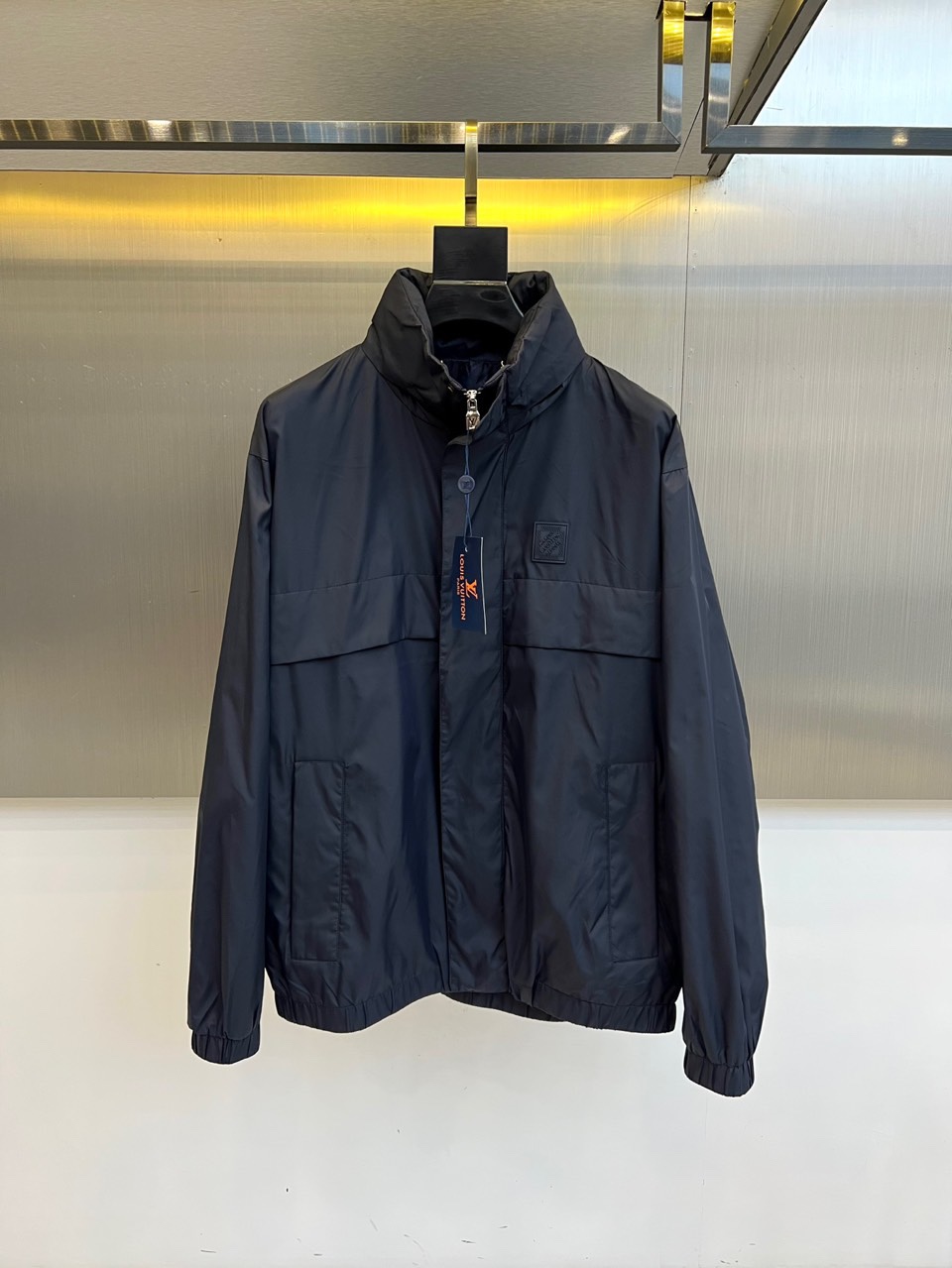 NO:529019,1v Vaderton, 2025 autumn and winter new jacket, interpreting modern urban luxury in deep navy blue. This jacket adopts a stand-up collar design with a metal zipper opening and closing system, and the left chest is decorated with a relief texture brand logo patch. The predecessor is equipped with two three-dimensional oblique pockets, which combine practical functions and line beauty. The fabric is made of high-tech knitted material, injected elastic fibers to ensure freedom of movement, and ribbed details to enhance the contour structure. The classic Monogr  The am elements are integrated into the fabric texture in the form of dark patterns, demonstrating the brand's genes in a low-key manner. The slim-fitting tailoring perfectly balances formal and casual sense, which can not only match suit pants to create an elite image, but also collimate with casual outfits to create a mixed-match charm. The iconic design language of the NBOSSD series runs through the whole time, allowing every detail to tell Louis Vuitton's redefinition of modern luxury. 48-56 (model 173, 143 catties upper body 50 yards),,louis  vuitton,jackets & coats,business suit,alexander wang198609091v威登、2025秋冬新品夹克,以深邃海军蓝诠释现代都市奢华.这款夹克采用立领设计搭配金属拉链开合系统,左胸饰有浮雕质感品牌标识贴片.前身配备两个立体斜插口袋,兼具实用功能与线条美感.面料选用高科技针织材质,注入弹性纤维确保活动自由度,罗纹细节收边强化轮廓结构感.将经典Monogram元素以暗纹形式融入面料肌理,在低调中彰显品牌基因.修身剪裁完美平衡正式与休闲感,既可搭配西装裤塑造精英形象,也能与休闲装碰撞出混搭魅力.NBOSSD系列标志性设计语言贯穿始终,让每处细节都诉说路易威登对现代奢华的重新定义.48-56（模特173,143斤上身50码）,,louis vuitton,jackets & coats,business suit,alexander wang,Men's clothing