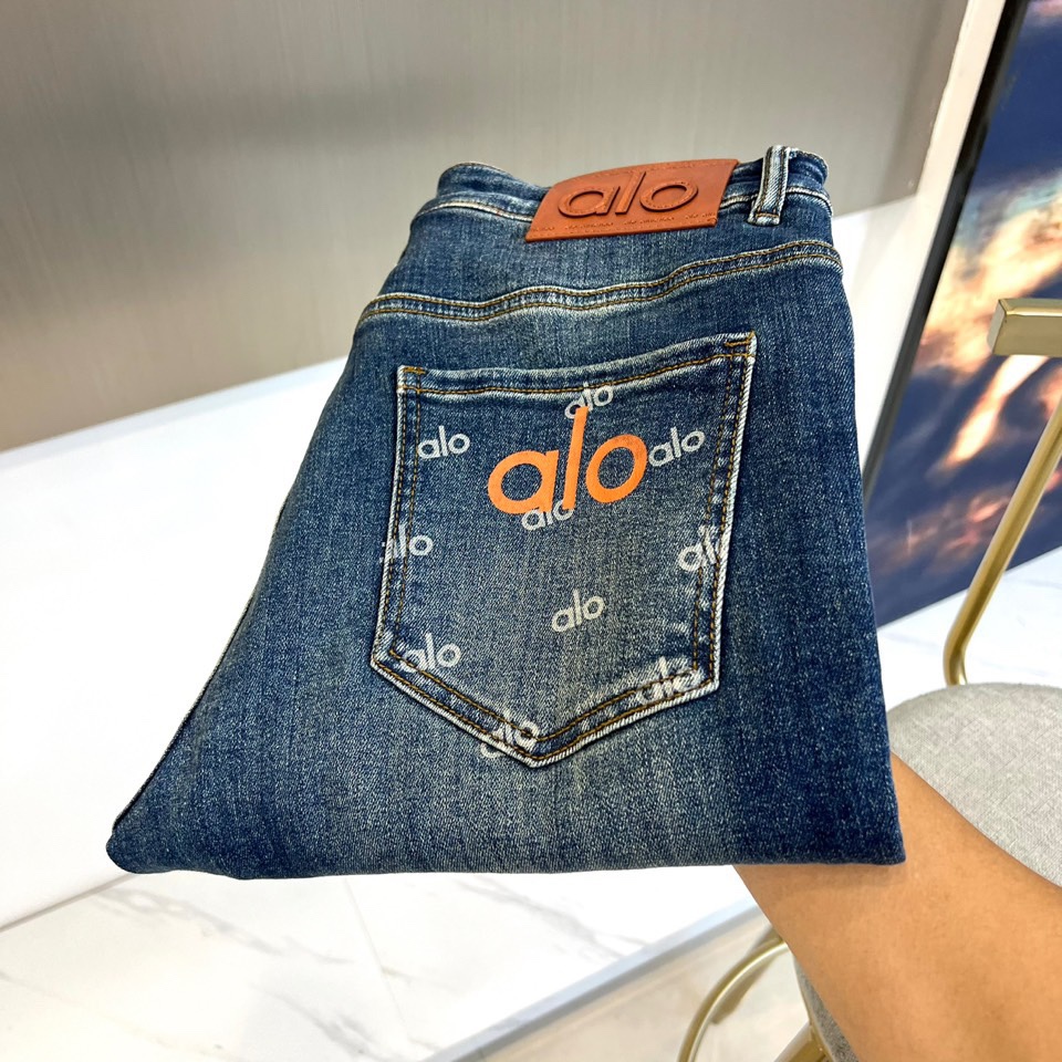 NO:529031,Alo-2025 autumn and winter new jeans are made of classic dark blue denim, presenting a retro washing effect, demonstrating the charm of timeless streets. In terms of style, the center of the back pocket uses the eye-catching orange three-dimensional letter 'Alo' as the core decoration, surrounded by the same color brand logo, forming a rich visual impact; the waist of the trousers is equipped with textured brown leather signs, and the brand abbreviation is clearly imprinted, and the details show exquisite craftsmanship. In terms of style, this jeans combine the casual unruly American street culture with the comfort and practicality of high-end sports and leisure. The orange and blue contrasting design injects vitality highlights, and at the same time, it enhances the overall texture through delicate stitching and fabric texture, perfectly interpreting the design concept of the 2025 autumn and winter series that combines functionality and fashion sense, suitable for daily wear for fashion enthusiasts who pursue personality and quality. 28-38 (no 37), , jeans, alexander  wang19860909Alo-2025秋冬新品牛仔裤,以经典深蓝色牛仔布打造,呈现复古水洗效果,彰显 timeless 街头魅力.款式上,后袋中央采用醒目橙色立体字母'Alo'作为核心装饰,周围环绕同色系品牌标识,形成层次丰富的视觉冲击；裤腰处配置质感棕色皮革标牌,压印清晰品牌缩写,细节处尽显精湛工艺.风格上,这款牛仔裤融合美式街头文化的随性不羁与高端运动休闲的舒适实用,橙蓝撞色设计注入活力亮点,同时通过细腻缝线和面料纹理提升整体质感,完美诠释2025秋冬系列兼具功能性与时髦度的设计理念,适合追求个性与品质的时尚爱好者日常穿搭.28-38（无37）,,jeans,alexander wang,Men's clothing
