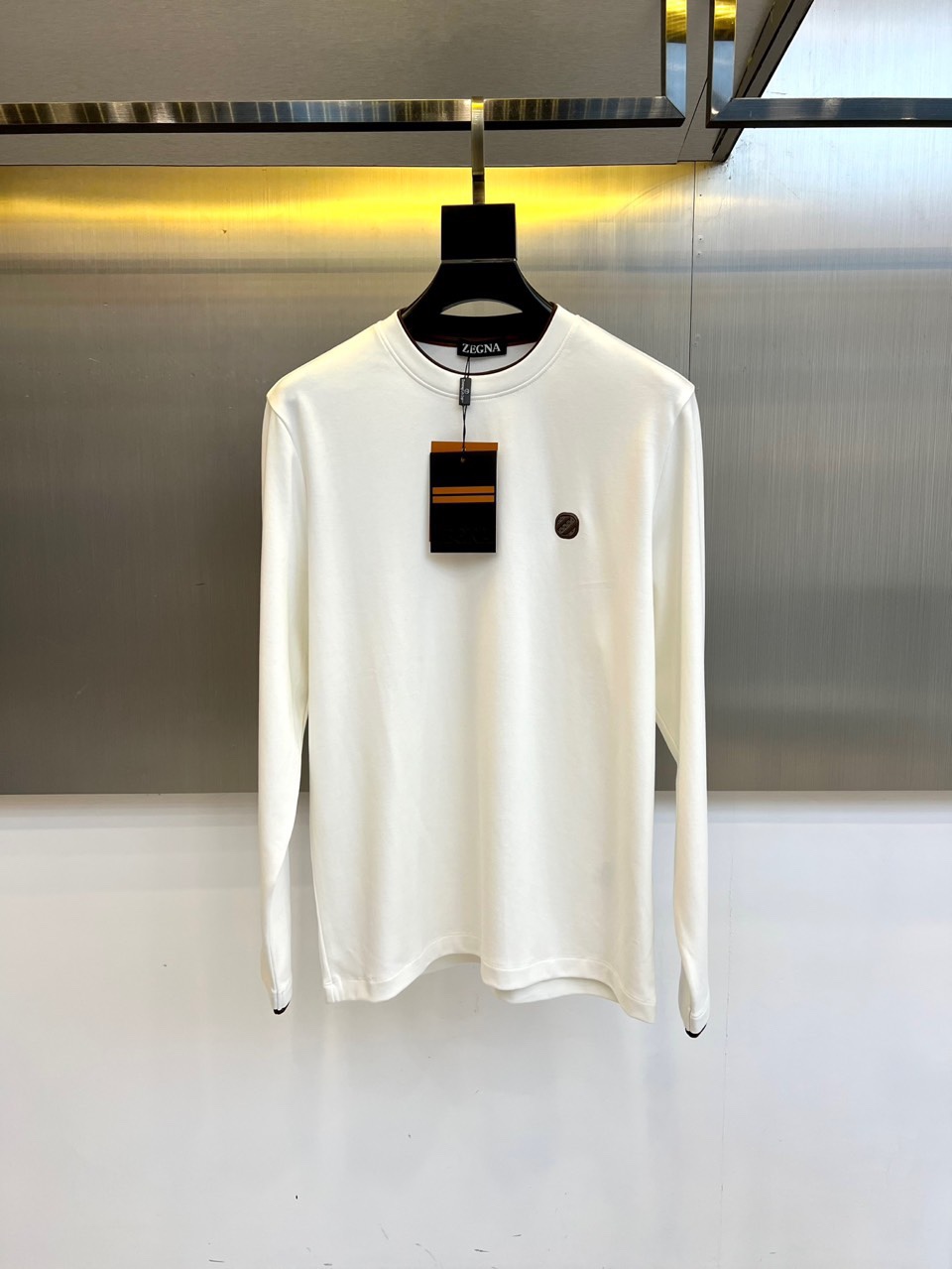 NO:529037,Zegna, the new Modal long-sleeved T-shirt base shirt for autumn and winter, interprets modern and luxurious aesthetics with minimalist design. This T-shirt uses a worsted mixed fabric of 46 cotton, 46 modal and 8 lycra, combining cotton's skin-friendly feel, modal's smooth drapery and excellent elasticity given by lycra. The slim-fitting cut is combined with the precise version, and the brand's iconic round badge is embroidered with the left chest, and the inner side of the collar is embroidered with a low-key 'ZEGNA' logo. The fabric has been processed with special craftsmanship to present a delicate texture, ensuring breathability and comfort when worn. The modal ingredients bring a velvety touch, and the lycra fiber provides four-way stretching freedom, leaving daily activities without any restraint. From business leisure to social scenes, it can be worn alone to show a simple and high-end feeling, and can also be used as an inner layer to highlight layered taste.  Integrate Italian craftsmanship into daily dress, so that every detail tells Zegna's ultimate pursuit of material and style. This T-shirt is not only a necessary basic style for the wardrobe, but also a choice to interpret the contemporary elite clothing style. 48-56 (model 173, 143 catties upper body 50 sizes), zegna,tees, t-shirt, alexander wang19860909Zegna杰尼亚、2025秋冬新品莫代尔长袖T恤打底衫,以极简设计诠释现代奢华美学.这款T恤采用46棉、46莫代尔与8莱卡的精纺混裁面料,兼具棉质的亲肤感、莫代尔的柔滑垂坠感以及莱卡赋予的卓越弹性.修身剪裁配合精准版型,左胸点缀品牌标志性圆形徽章,衣领内侧绣有低调的'ZEGNA'标识. 面料经过特殊工艺处理,呈现细腻的肌理质感,确保穿着时透气性与舒适度并存.莫代尔成分带来丝绒般触感,莱卡纤维提供四向拉伸自由度,让日常活动毫无束缚.从商务休闲到生活社交场景皆宜,既能单穿展现简约高级感,也可作为内搭凸显层次品味. 将意大利匠心工艺融入日常着装,让每一处细节都诉说杰尼亚对材质与版型的极致追求.这款T恤不仅是衣橱必备基础款,更是诠释当代精英衣品的选择.48-56（模特173,143斤上身50码）,,zegna,tees，t-shirt,alexander wang,Men's clothing