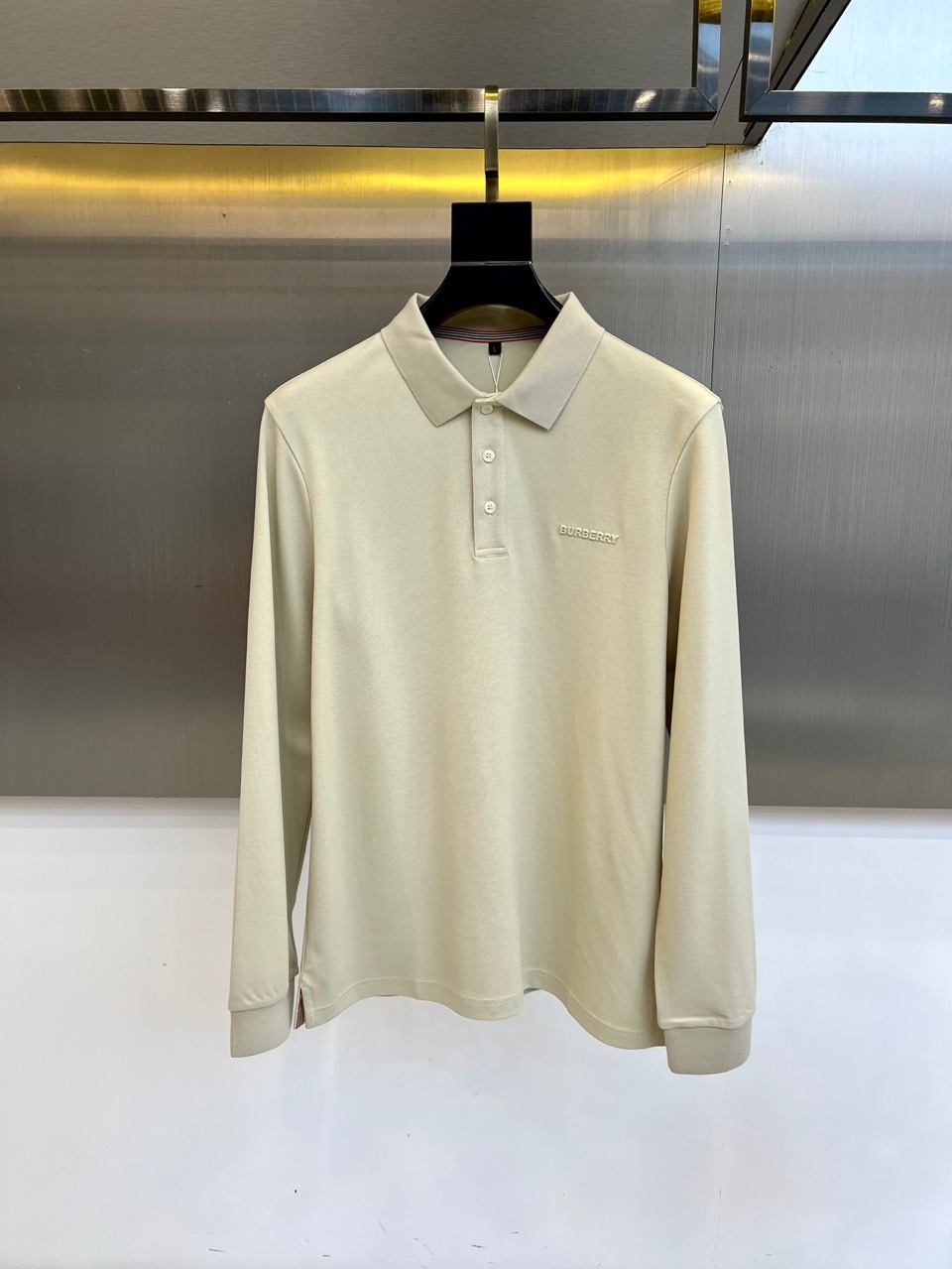 BUR巴宝莉、 2025秋冬新品长袖Polo衫，以经典翻领设计诠释现代英伦美学。领口配备三粒珠光白纽扣，