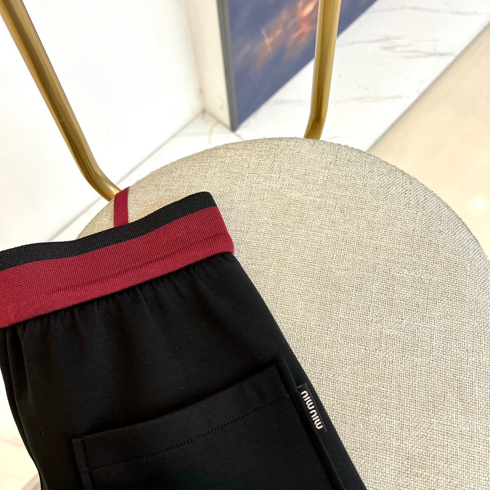 Miu Miu 2025秋冬新品米白色休闲裤，以纯净色调演绎现代少女式叛逆。腰头处饰有酒红色镶边撞色设计