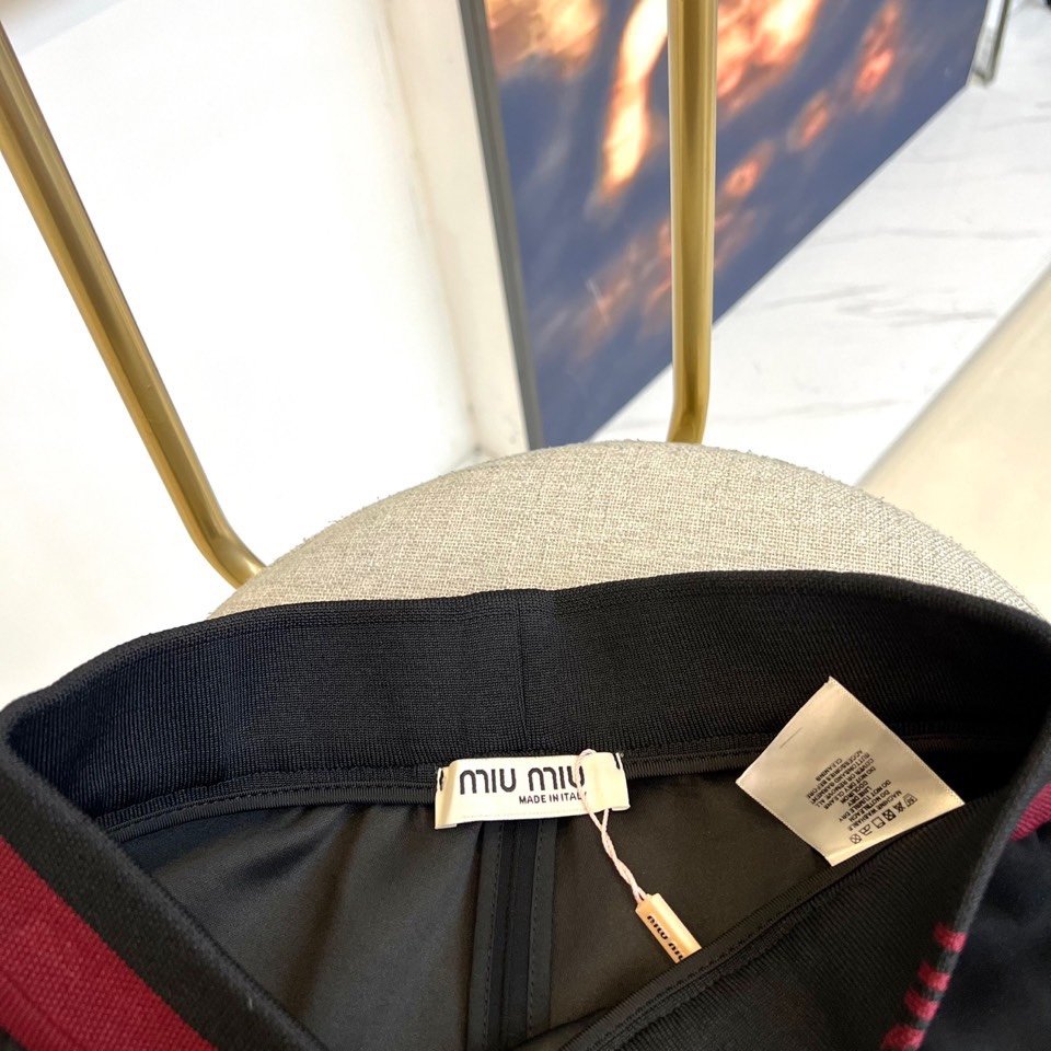 Miu Miu 2025秋冬新品米白色休闲裤，以纯净色调演绎现代少女式叛逆。腰头处饰有酒红色镶边撞色设计