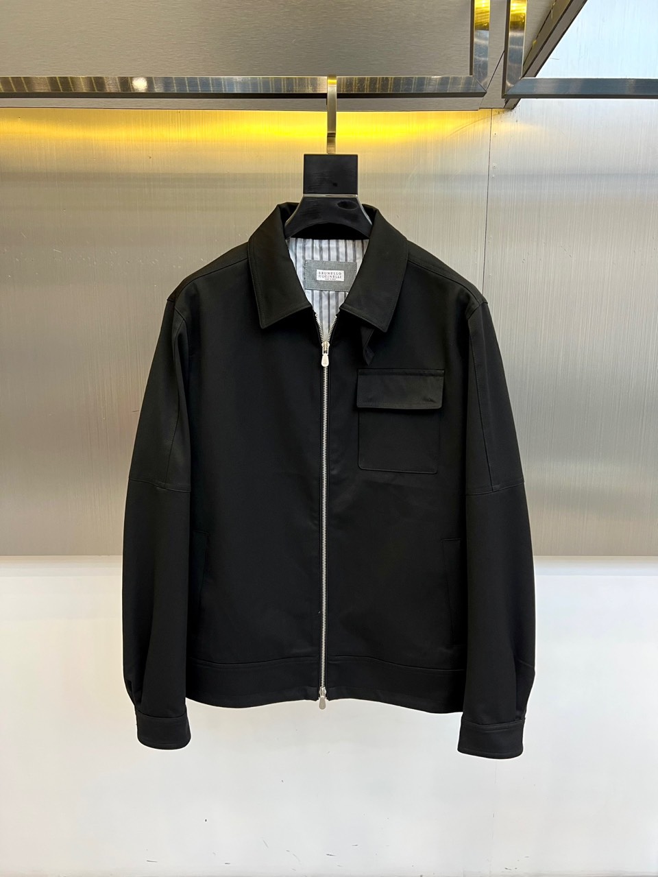 NO:595866,Brunello Cucinelli's 2025 autumn and winter new lapel jacket interprets Italian low-key luxury with top-quality cotton blended fabrics. The stand-up collar design is equipped with a metal zipper opening and closing system. The left chest is equipped with a square pocket with a lid, and the diagonal pockets on both sides are embedded in the body at a precise angle, taking into account practical functions and smooth lines. The lining uses the brand's iconic stripe pattern, revealing elegant genes in the details.  The fabric is made of high-count cotton blend, which is delicate and has excellent wrinkle resistance. All metal accessories have been distressed, which harmoniously echoes the overall tone of the jacket. The shoulders are made of three-dimensional cutting technology to ensure that the silhouette is maintained while providing ample room for movement. The overall style perfectly balances business formal wear and casual atmosphere. It can be paired with shirts and trousers to show elite style, or with casual knitting to create an urban strolling look. From lining stripes to distressed metal details, every design reflects Brunello  Cucinelli's persistent pursuit of the concept of 'silent luxury' has become a model for autumn and winter wardrobes that combines practicality with brand recognition. Professional dry cleaning is recommended to maintain the fabric texture and pattern structure. 48-56 (model 173,143 pounds, upper body size 50),, brunello cucinelli, jackets & coats, shirts, alexander wang19860909Brunello Cucinelli 2025秋冬新品翻领夹克,以顶级棉质混纺面料诠释意式低调奢华.立领设计搭配金属拉链开合系统,左胸配备带盖方形口袋,两侧斜插口袋以精准角度嵌入衣身,兼顾实用功能与流畅线条.内衬采用品牌标志性条纹图案,于细节处流露优雅基因. 面料选用高支棉混纺材质,呈现细腻,卓越抗皱性能.所有金属配件均经过做旧处理,与夹克整体色调形成和谐呼应.肩部采用立体剪裁工艺,确保穿着时保持挺括轮廓的同时提供充足活动空间. 整体风格完美平衡商务正装与休闲气息,既可搭配衬衫西裤展现精英风范,亦可搭配休闲针织塑造都市漫步造型.从内衬条纹到做旧金属细节,每处设计都体现Brunello Cucinelli对'无声奢华'理念的执着追求,成为秋冬衣橱中兼具实穿性与品牌辨识度的典范之作.建议专业干洗以保持面料质感与版型结构.48-56（模特173,143斤上身50码）,,brunello cucinelli,jackets & coats,shirts,alexander wang,Men's clothing