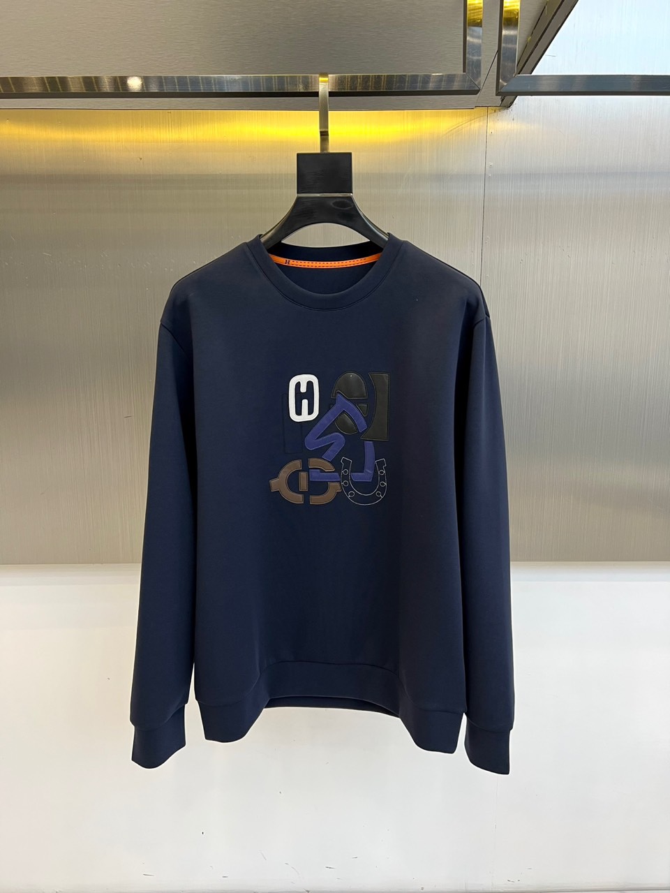 NO:595858,H Hermès, 2025 autumn and winter new round-neck sweatshirt, uses innovative air-layer fabric to interpret contemporary leisure luxury. It uses exclusive double-layer weaving technology to create a light and three-dimensional silhouette, and the main gray tone presents a high-end texture. The chest is decorated with the brand's iconic three-dimensional letter pattern——  Bright yellow 'H', pure white 'Λ' and dark blue 'G' are arranged in a staggered manner to form the visual focus. The letters are embroidered with precision to create a concave and convex texture, shining like a metal nameplate. It highlights the precisely tailored shoulder line outline. The ribbed crew neck and cuffs are thickened.  To ensure warmth, the slightly tapered hem design balances comfort and neatness. It can be paired with leather trousers to create a modern urban style, or combined with a skirt to create a French casual look. It interprets Hermès' design philosophy of integrating traditional craftsmanship with modern aesthetics, becoming an autumn and winter coat.  Collectible items in the closet that are both artistic and practical. 48-56 (model weighs 173,143 pounds, upper body size 50), hermes, hoodie, sweatshirts, skirts, alexander  wang19860909H爱马仕、2025秋冬新品圆领卫衣,以创新空气层面料诠释当代休闲奢华.采用独家双层织造技术打造轻盈立体的廓形,灰色主调呈现高级质感.胸前饰有品牌标志性立体字母图案——明黄色'H'、纯白色'Λ'与深蓝色'G'以错位排列构成视觉焦点,字母采用精密刺绣工艺呈现凹凸肌理,宛如金属铭牌般闪耀.凸显精准剪裁的肩线轮廓.罗纹圆领与袖口采用加厚处理确保保暖性,下摆微收设计兼顾舒适与利落感.既能搭配皮革长裤演绎都市摩登风格,亦可与半裙组合打造法式休闲造型.诠释爱马仕将传统工艺与现代美学相融合的设计哲学,成为秋冬衣橱中兼具艺术性与实穿性的收藏级单品.48-56（模特173,143斤上身50码）,,hermes,hoodie,sweatshirts,skirts,alexander wang,Men's clothing