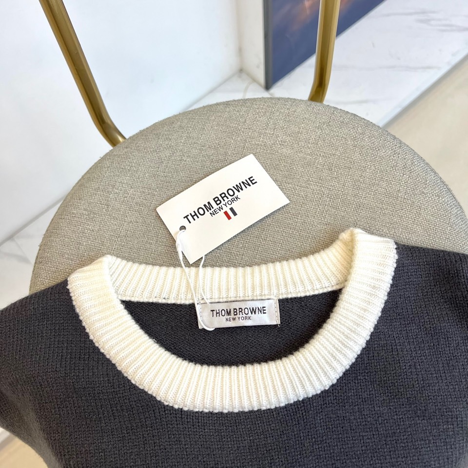 TB 2025秋冬新品深灰色针织毛衣，以经典圆领设计与标志性条纹元素诠释现代学院风美学。呈现细腻的深灰色