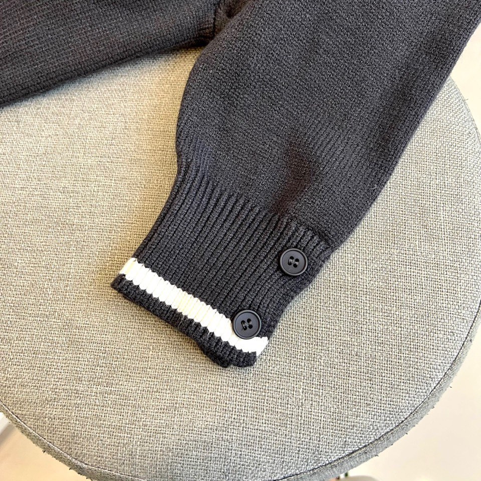 TB 2025秋冬新品深灰色针织毛衣，以经典圆领设计与标志性条纹元素诠释现代学院风美学。呈现细腻的深灰色