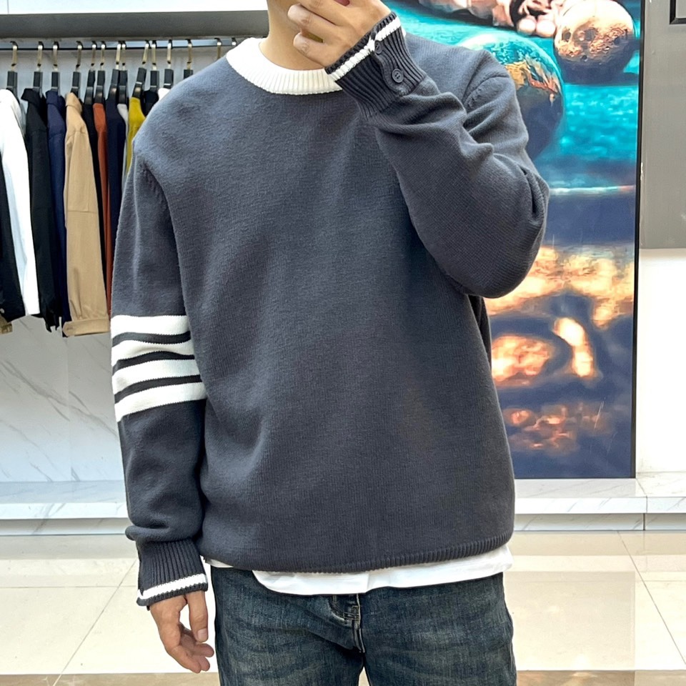 TB 2025秋冬新品深灰色针织毛衣，以经典圆领设计与标志性条纹元素诠释现代学院风美学。呈现细腻的深灰色