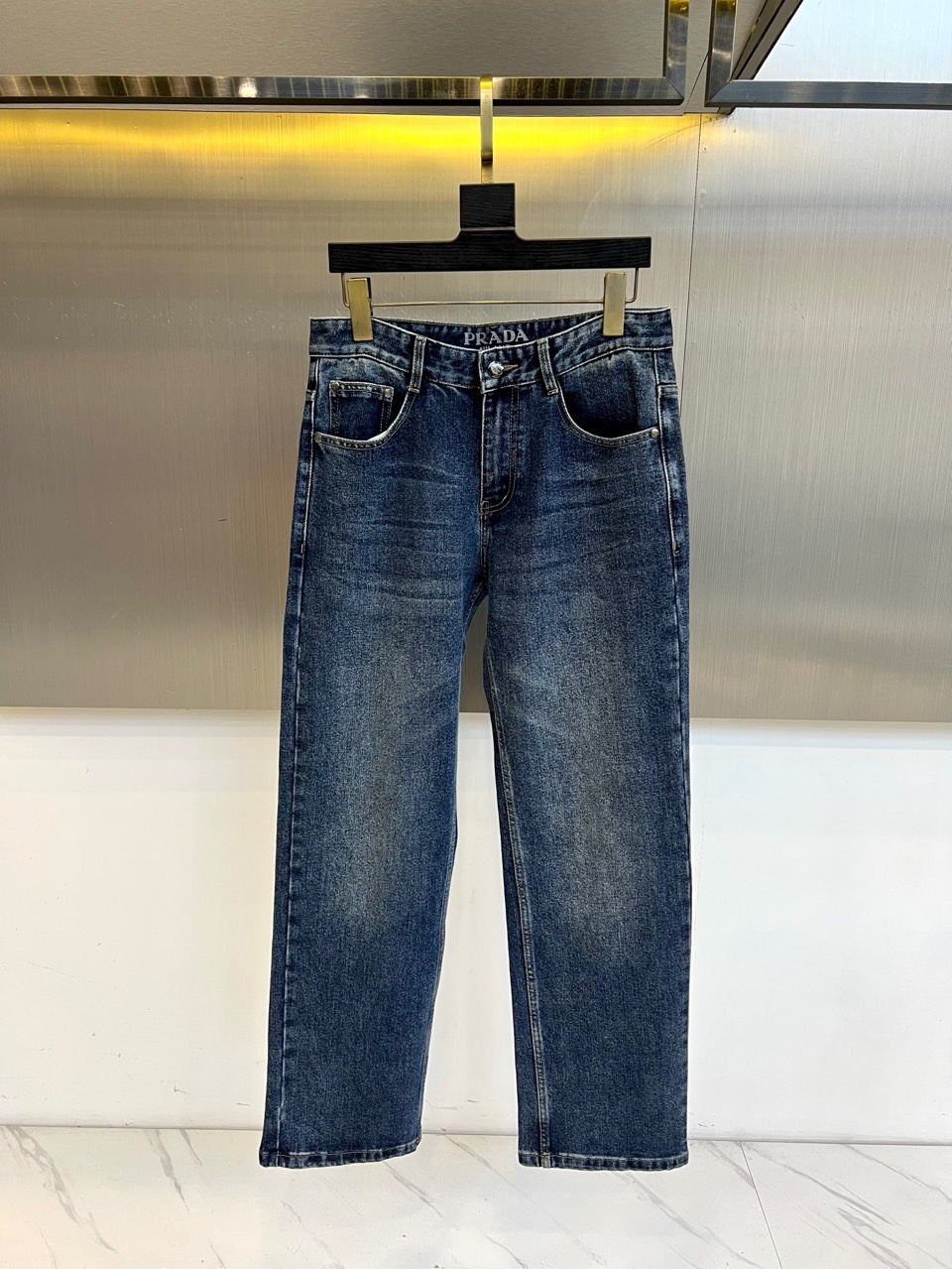 Prad普拉、2025秋冬新品男士深蓝色牛仔裤，以经典直筒剪裁诠释意式奢华美学。裤腰内侧饰有品牌压印标识