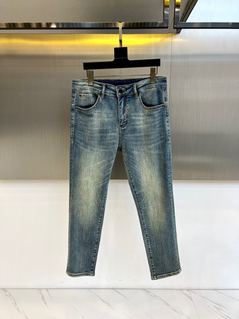 VT华伦天奴、2025秋冬新品经典蓝牛仔裤，以复古水洗蓝重塑美式休闲美学。后袋饰有精致的金色马蹄铁形刺绣