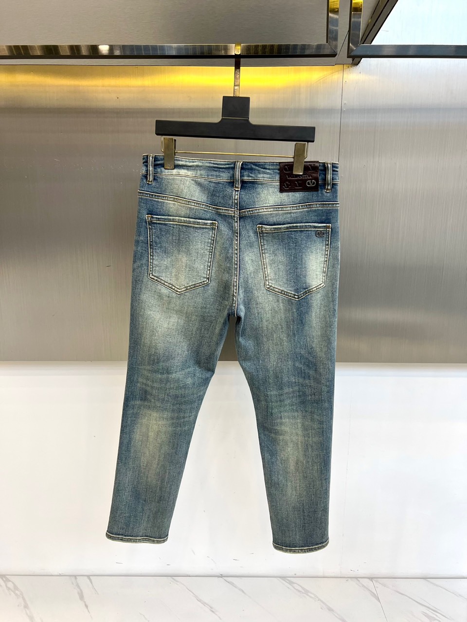 VT华伦天奴、2025秋冬新品经典蓝牛仔裤，以复古水洗蓝重塑美式休闲美学。后袋饰有精致的金色马蹄铁形刺绣