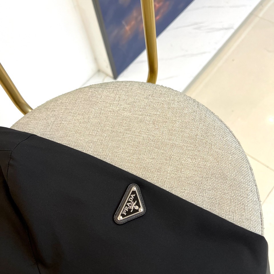 Prada普拉、2025秋冬新品连帽外套，以极致简约的线条诠释现代实用主义美学。采用高科技哑光黑色面料打