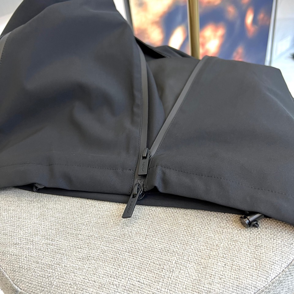 Prada普拉、2025秋冬新品连帽外套，以极致简约的线条诠释现代实用主义美学。采用高科技哑光黑色面料打