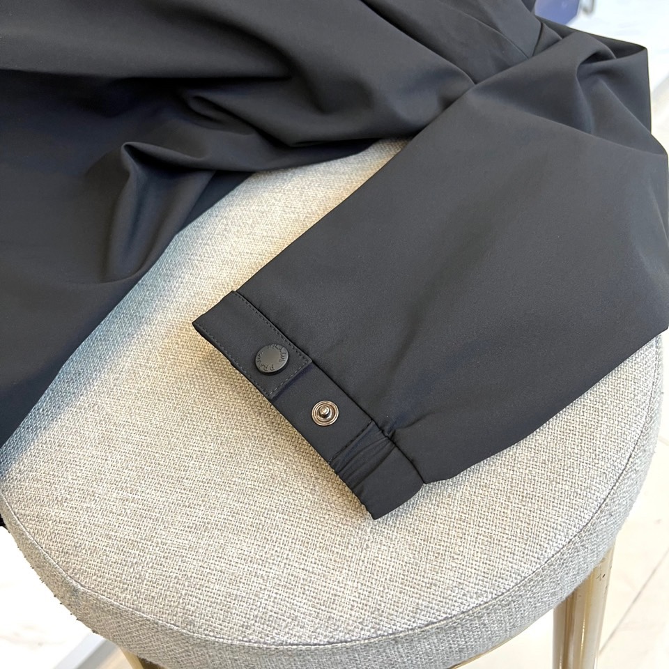 Prada普拉、2025秋冬新品连帽外套，以极致简约的线条诠释现代实用主义美学。采用高科技哑光黑色面料打