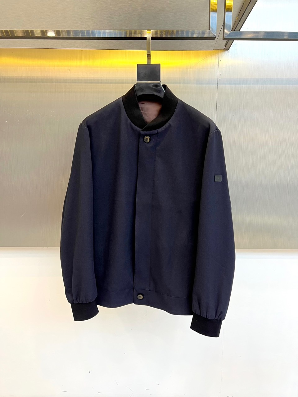 NO:595855,Zegna, 2025 autumn and winter old money style men's business casual fashion cashmere wool blend loose baseball collar jacket. Made of dark blue cashmere wool blend fabric, showing a delicate matte texture and excellent warmth retention. The baseball collar design uses contrasting black trim, and the collar, cuffs and hem are all available  It is made of rib knitted material of the same color to form a refined visual hierarchy. The front of the body is equipped with two hand-polished matte metal buttons, and the brand's iconic square logo embroidery is decorated on the top of the left sleeve. The details highlight Italian craftsmanship. The loose fit combines modern comfort with an elegant silhouette, and the internal space is easy to layer with suits.  Or knitted items. The style perfectly interprets the low-key luxury of 'old money style'. The dark blue tone is calm and restrained, and the blended material gives the item a high-end texture. It can be paired with formal trousers to create a business casual look, or it can be paired with casual trousers to show the calm temperament of an urban elite. This jacket is suitable for a variety of semi-formal occasions.  , From high-end business meetings to private social gatherings, it can show the wearer's precise grasp of quality and style, reflecting Zegna's brand essence of integrating traditional craftsmanship with modern aesthetics. 48-56 (model weighs 173,143 pounds, upper body size 50),,zegna,jackets  & coats,jackets & coats,business suit,alexander wang19860909Zegna杰尼亚、2025秋冬老钱风男款商务休闲时装羊绒羊毛混纺宽松棒球领夹克外套.以深蓝色羊绒羊毛混纺面料打造,呈现细腻哑光质感与卓越保暖性.棒球领设计采用对比色黑色镶边,领口、袖口及下摆均选用同色系罗纹针织材质,形成精致视觉层次.衣身正面配备两粒手工打磨的哑光金属纽扣,左袖上方饰有品牌标志性方形徽标刺绣,细节处彰显意大利匠心工艺.宽松版型兼顾现代舒适度与优雅轮廓,内部空间便于叠搭西装或针织单品.风格上完美诠释'老钱风'的低调奢华,深蓝色调沉稳内敛,混纺材质赋予单品高级肌理感,既能搭配正装裤履打造商务休闲造型,亦可搭配休闲长裤展现都市精英的从容气质.这款夹克适合多种半正式场合,从高端商务会晤到私人社交聚会,皆能展现穿着者对品质与风格的精准把握,体现Zegna将传统工艺与现代美学相融合的品牌精髓.48-56（模特173,143斤上身50码）,,zegna,jackets & coats,jackets & coats,business suit,alexander wang,Men's clothing