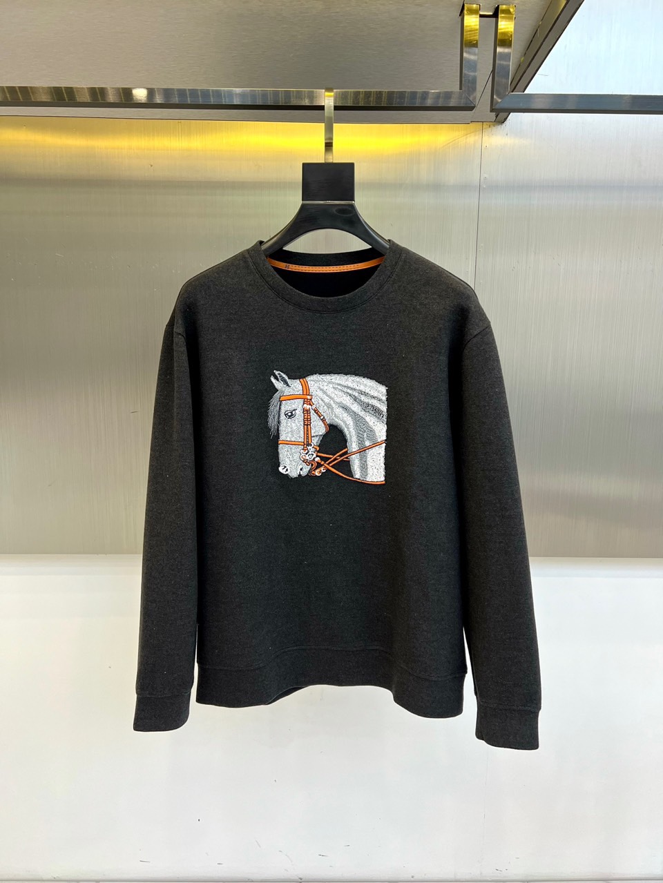 NO:595847,HERM, the new light gray round-neck sweatshirt for autumn and winter 2025, uses innovative air layer fabric to interpret contemporary French casual aesthetics. It uses exclusive double-layer weaving technology to create a light and three-dimensional silhouette, and the surface of the fabric presents a delicate micro-texture texture, which is both excellent and  Warmth and breathability. The chest is decorated with the brand's iconic horse head embroidery pattern - the reins are finely outlined with red stitching, and the horse's look is lifelike, continuing Hermès' long equestrian heritage. The ribbed round collar and cuffs are thickened, and the hem is slightly tapered.  The design ensures neat tailoring. It can be paired with white casual trousers to create an urban minimalist style, or it can be paired with dark leather bottoms to create a modern look that is both strong and soft. It interprets Hermès’ design philosophy of integrating traditional craftsmanship with technical fabrics, and has become an iconic item in the autumn and winter wardrobe that is both comfortable and collectible. 48-56 (model 173, 143 pounds, upper body size 50),, hermes, hermes, hoodie, sweatshirts, alexander  wang19860909HERM爱马仕、2025秋冬新品浅灰色圆领卫衣,以创新空气层面料诠释当代法式休闲美学.采用独家双层织造技术打造轻盈立体的廓形,面料表面呈现细腻的微肌理质感,兼具卓越保暖性与透气功能.胸前饰有品牌标志性马头刺绣图案——缰绳部分采用红色缝线精细勾勒,马匹神态栩栩如生,延续爱马仕悠久的马术传承基因.罗纹圆领与袖口采用加厚处理,下摆微收设计确保利落剪裁.既能搭配白色休闲长裤演绎都市极简风格,亦可与深色皮革下装碰撞出刚柔并济的摩登造型.诠释爱马仕将传统手工艺与科技面料相融合的设计哲学,成为秋冬衣橱中兼具舒适度与收藏价值的标志性单品.48-56（模特173,143斤上身50码）,,hermes,hermes,hoodie,sweatshirts,alexander wang,Men's clothing