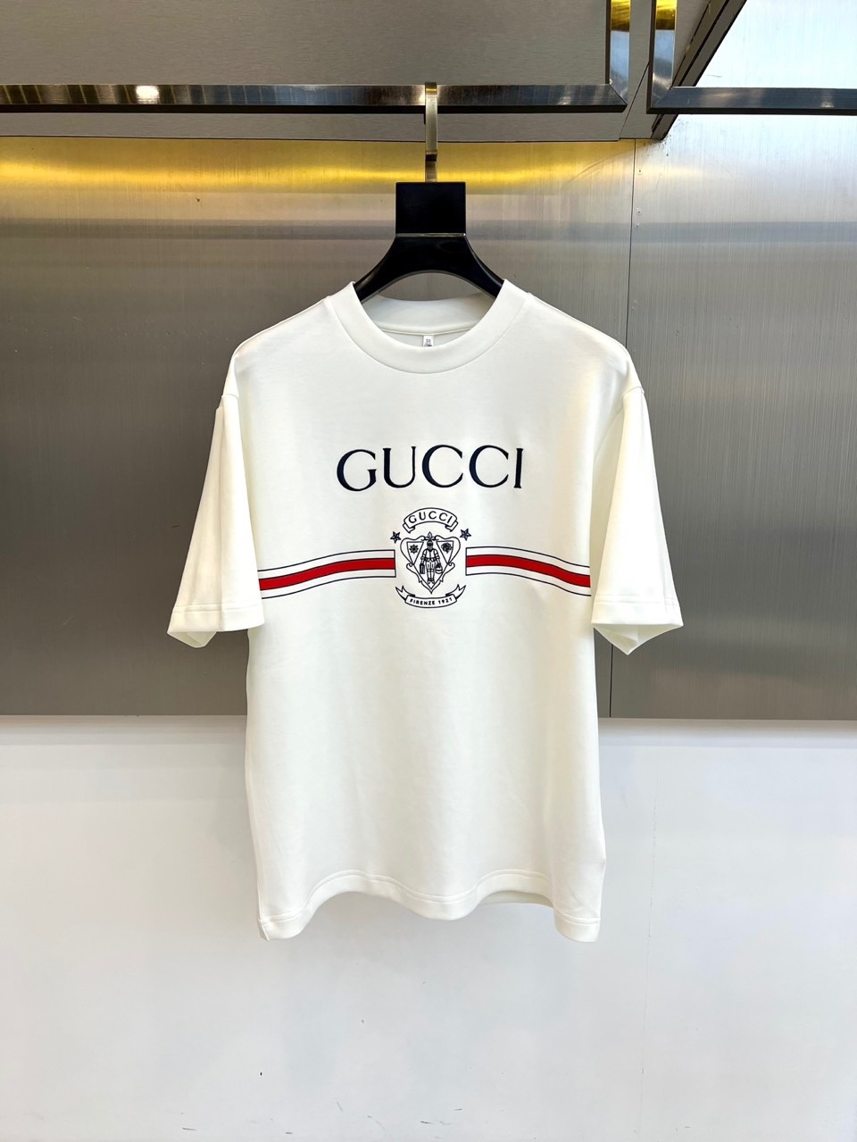Gucc古驰、2025秋冬新品GU家经典徽章短袖T恤,这款白色T恤以简约设计展现品牌美学,胸前居中排列的