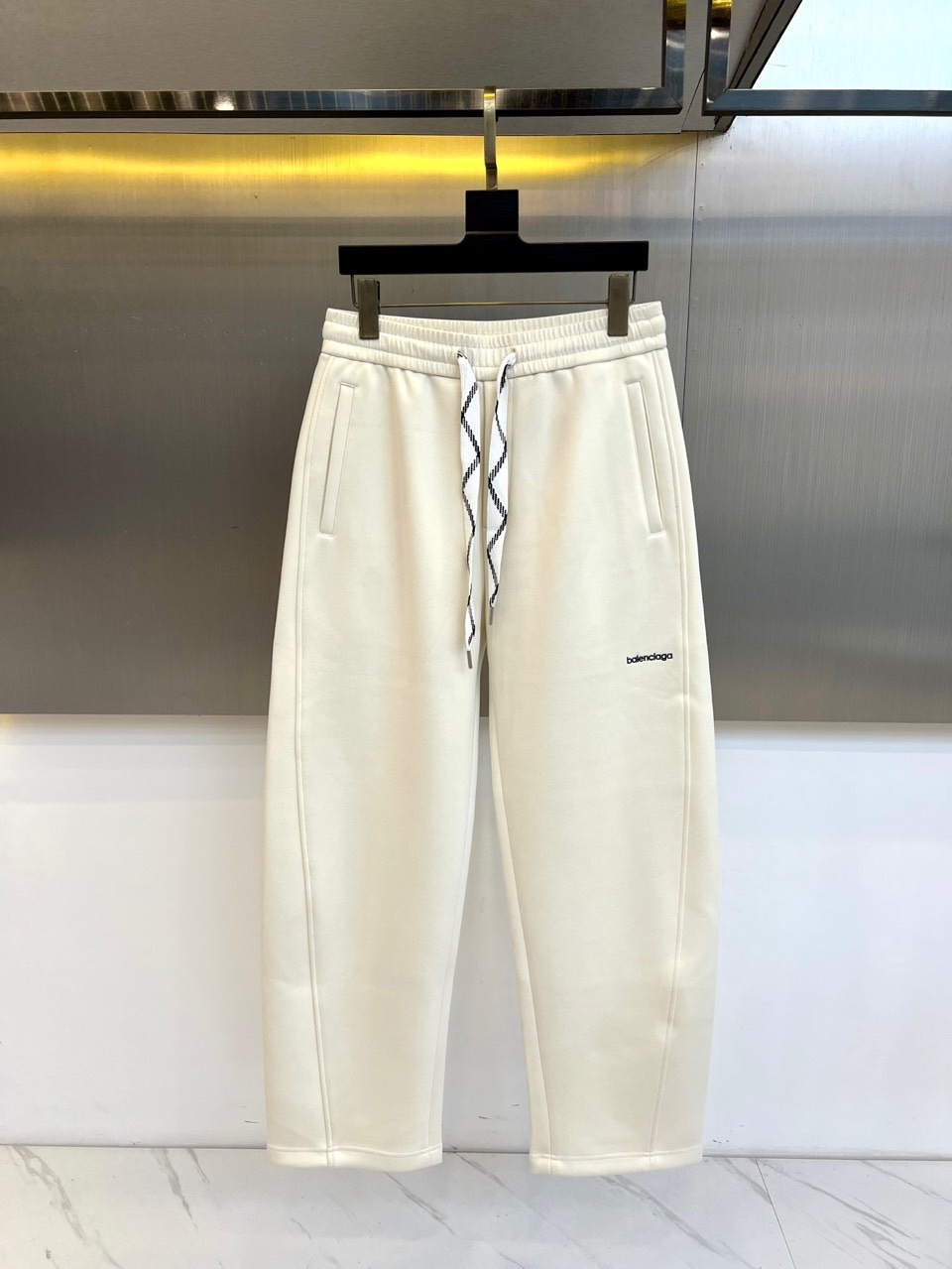 BALENCIAGA巴黎世家、2025秋冬新品男士休闲弯刀裤,这款休闲裤采用标志性弯刀版型设计,立体剪裁