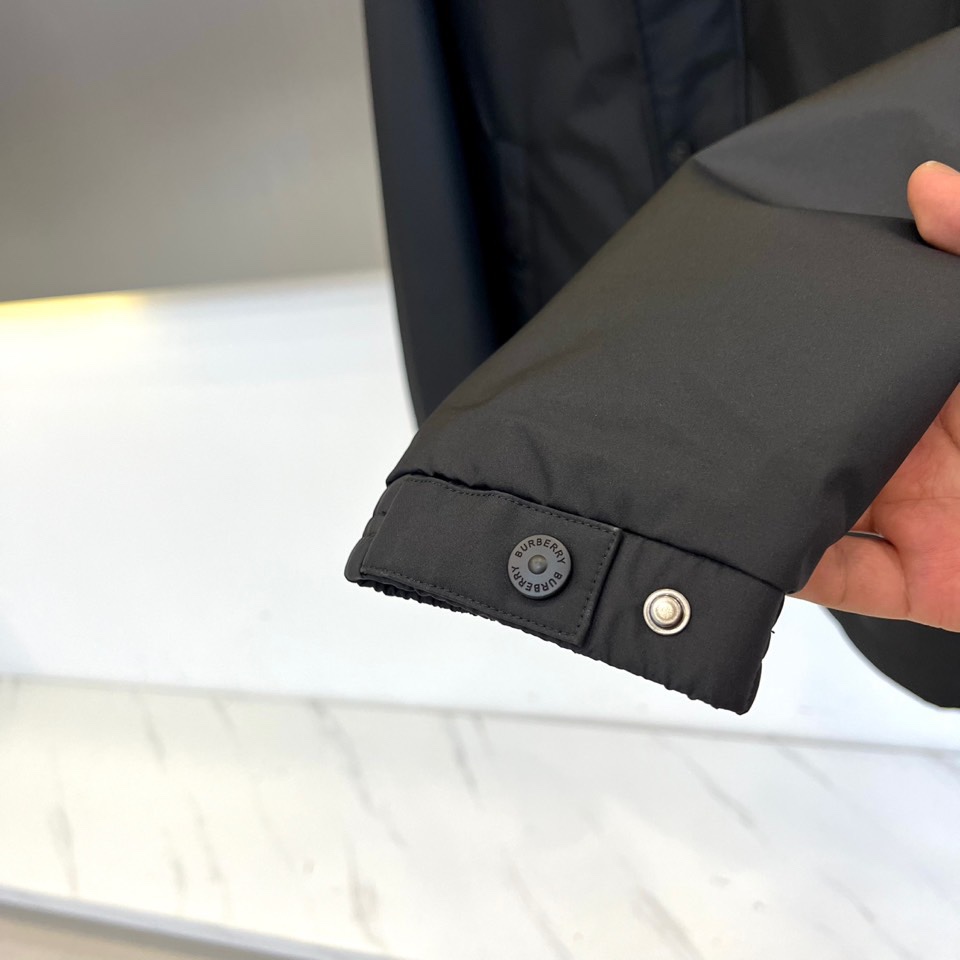 Bur巴宝莉、2025秋冬新品男士棉服夹克外套，以经典黑色演绎现代英伦风尚。连帽设计搭配单排扣开合，利落