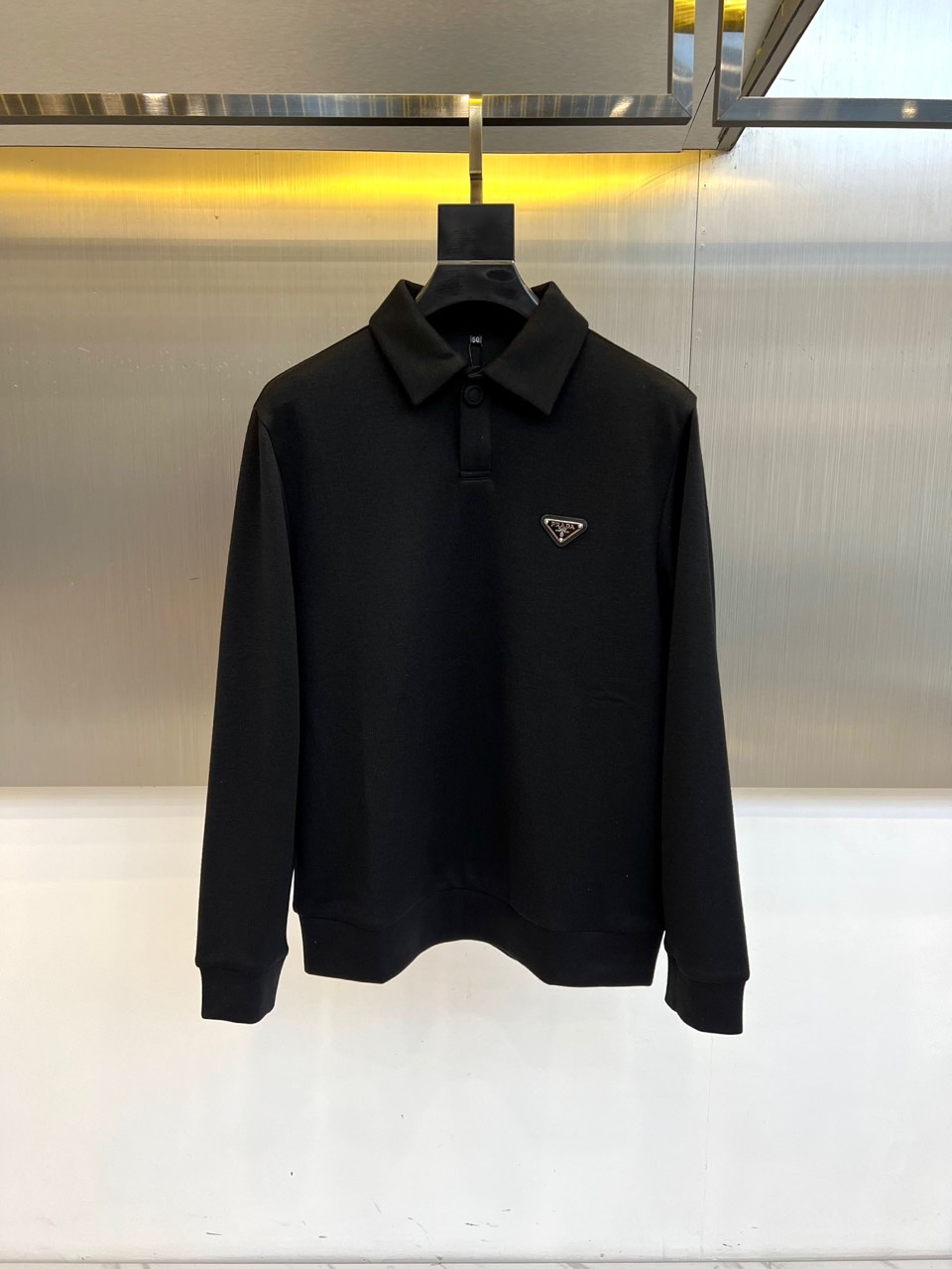 Prad普拉、2025秋冬新品 PRADA翻领设计羊绒桑蚕丝卫衣，这款黑色长袖上衣采用精致翻领设计，领口