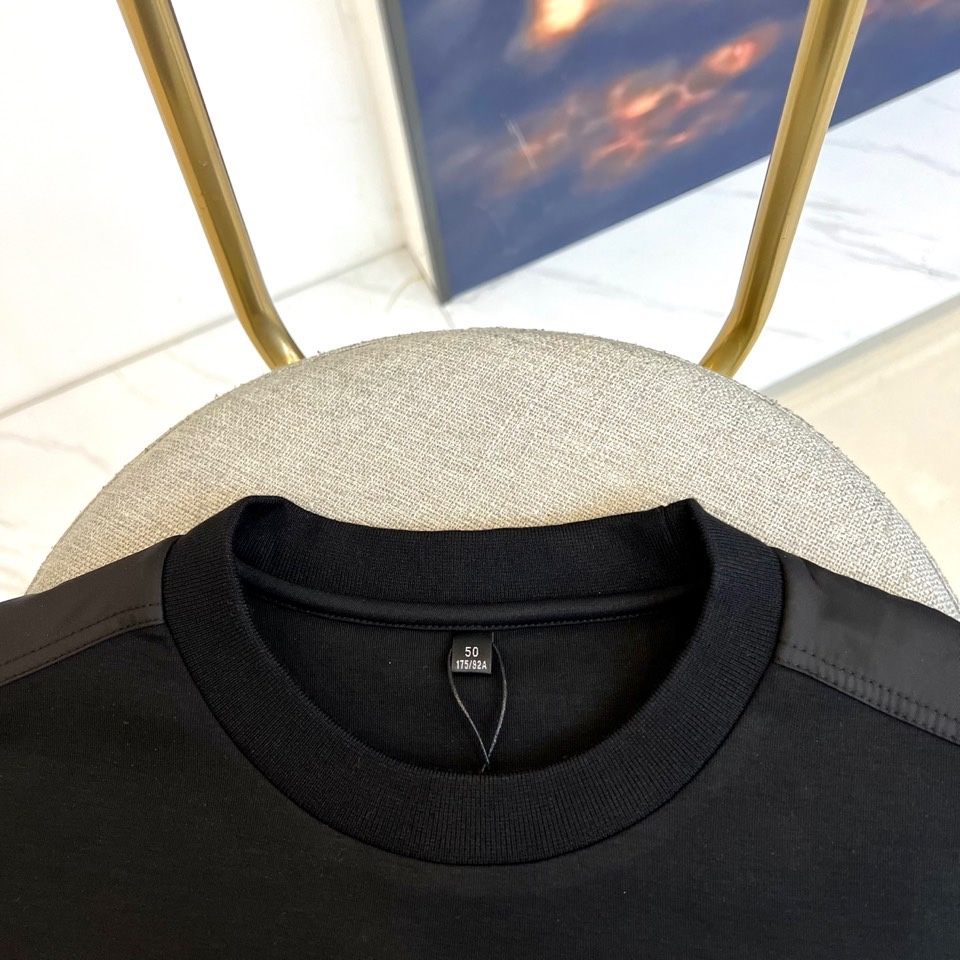 Prad普拉、2025秋冬新品 P家极简功能卫衣。这款黑色圆领卫衣采用简约立体剪裁，左臂处的银色拉链口袋