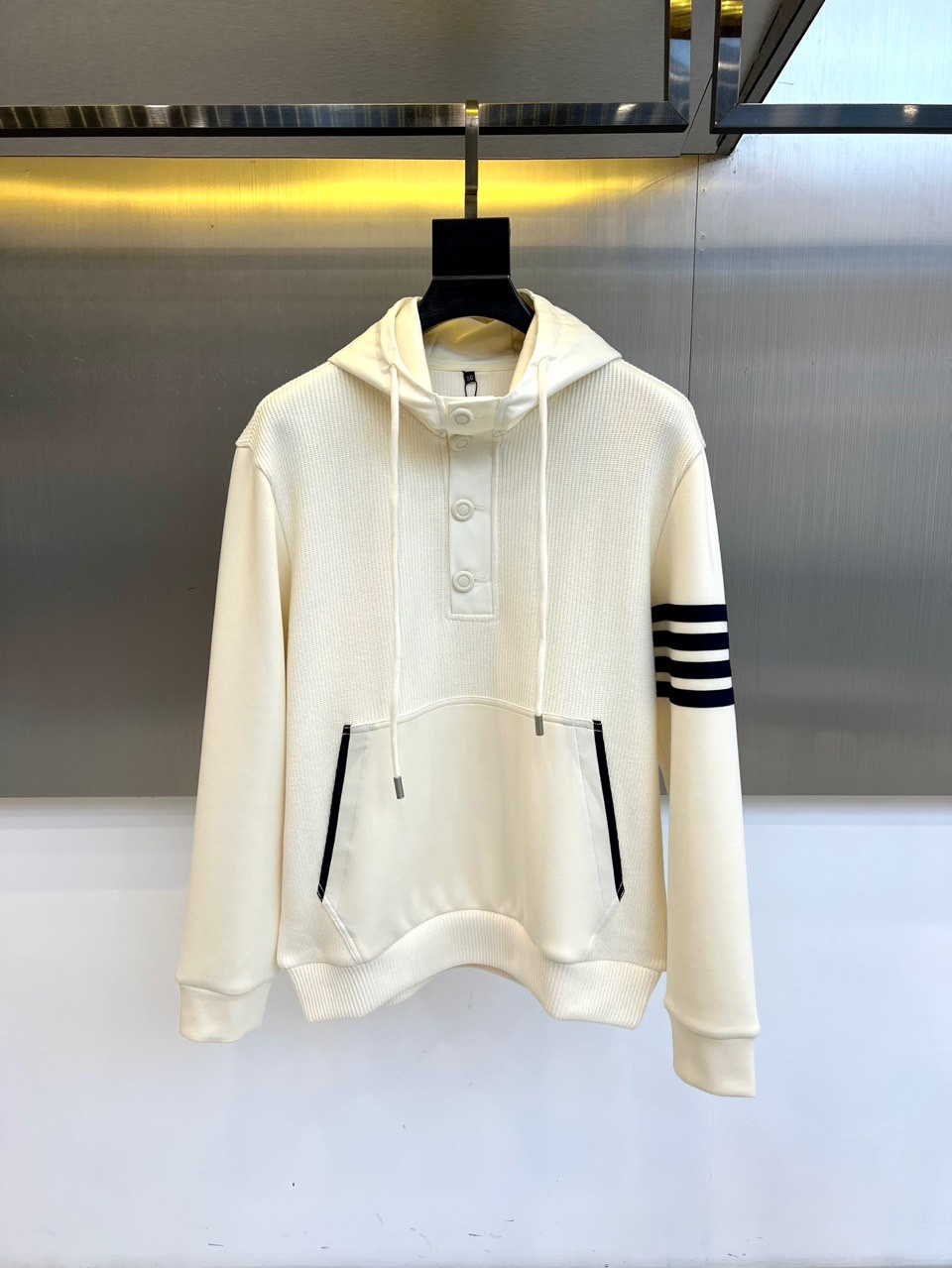 TB汤姆布朗尼、2025秋冬新品男士排扣连帽卫衣，简约设计蕴含高级质感，这件米白色卫衣注定成为你秋冬衣橱