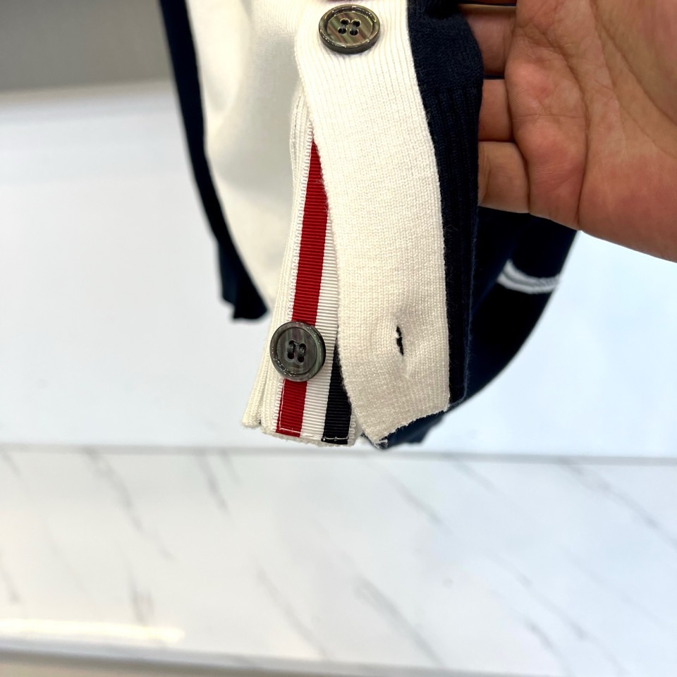 TB汤姆布朗、2025秋冬新品羊毛🦙针织开衫，以灰白拼接设计演绎童趣时尚美学。V领造型搭配黑色纽扣开合，