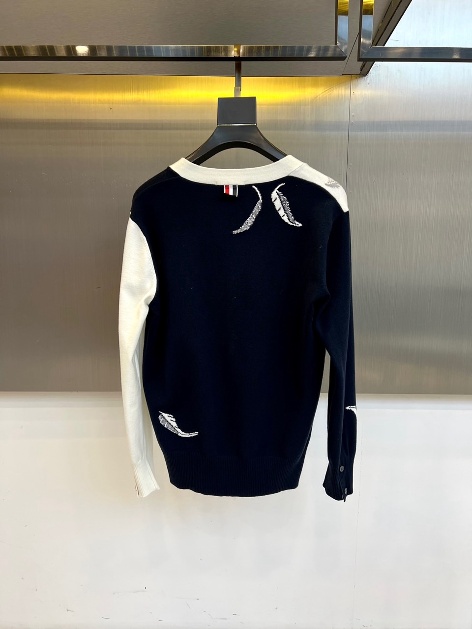 TB汤姆布朗、2025秋冬新品羊毛🦙针织开衫，以灰白拼接设计演绎童趣时尚美学。V领造型搭配黑色纽扣开合，