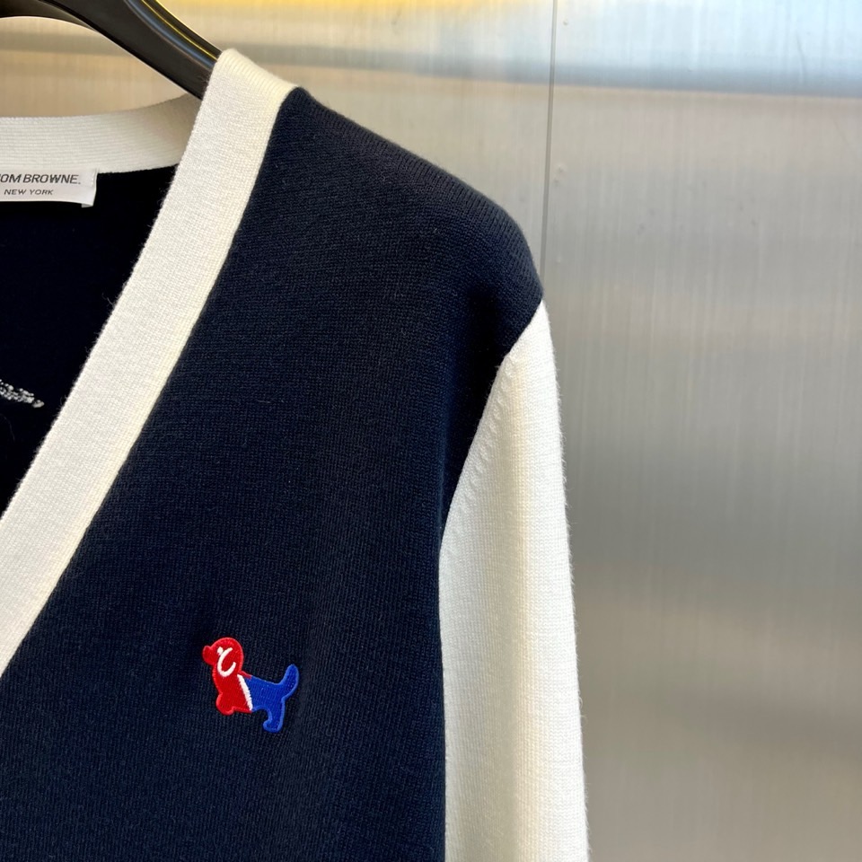 TB汤姆布朗、2025秋冬新品羊毛🦙针织开衫，以灰白拼接设计演绎童趣时尚美学。V领造型搭配黑色纽扣开合，