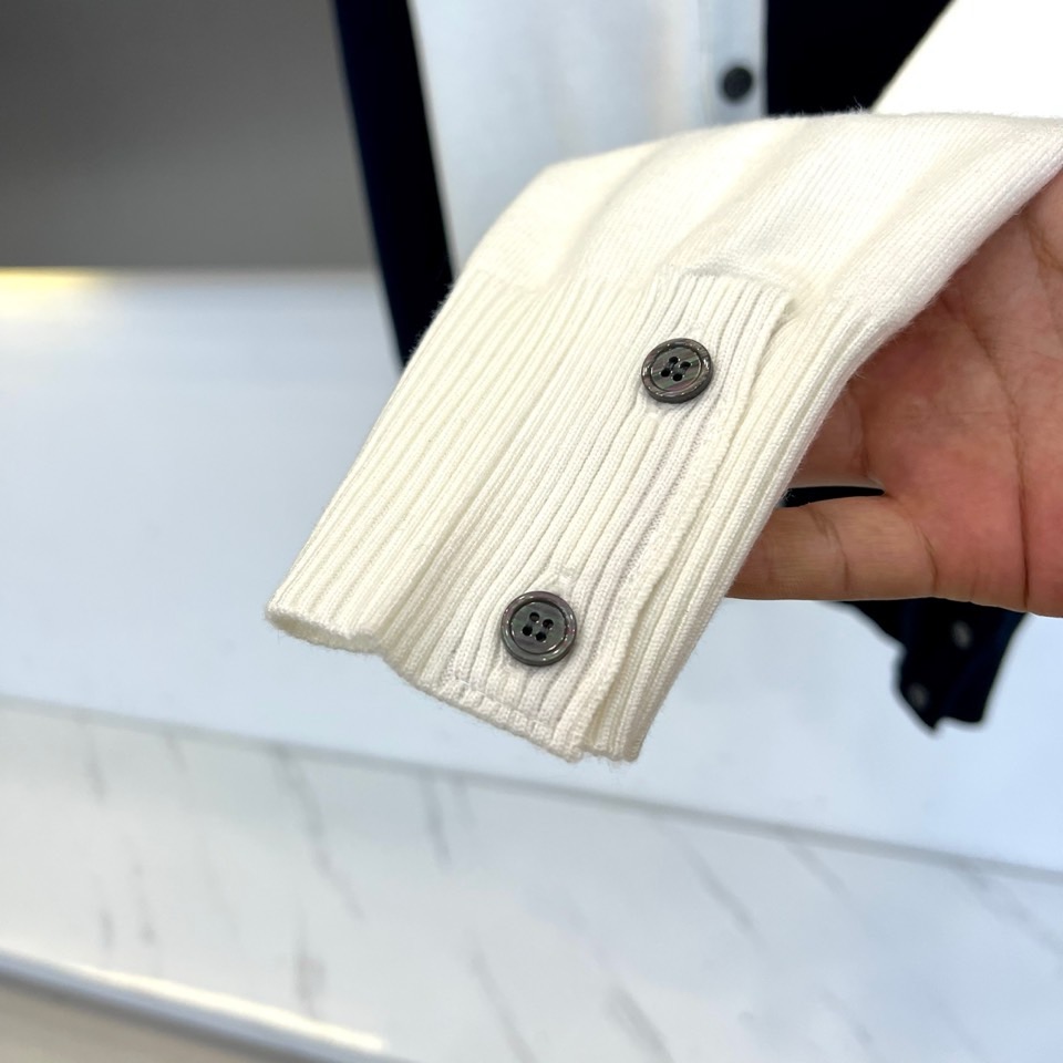 TB汤姆布朗、2025秋冬新品羊毛🦙针织开衫，以灰白拼接设计演绎童趣时尚美学。V领造型搭配黑色纽扣开合，