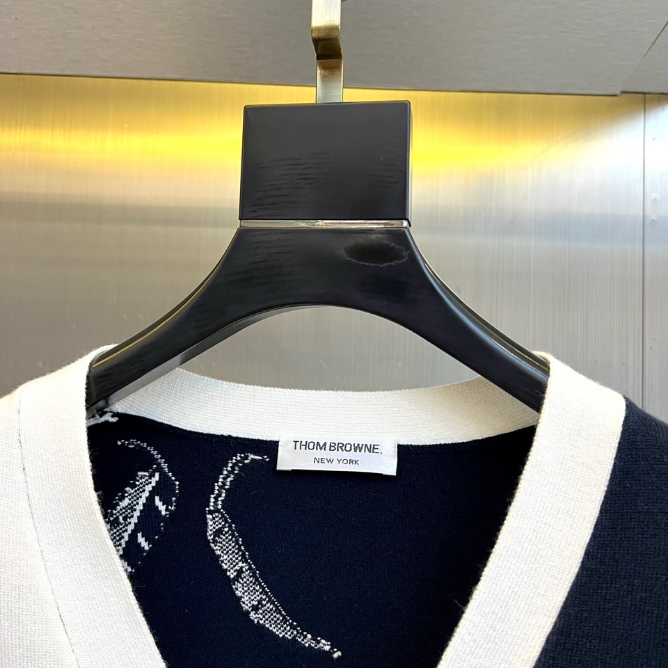 TB汤姆布朗、2025秋冬新品羊毛🦙针织开衫，以灰白拼接设计演绎童趣时尚美学。V领造型搭配黑色纽扣开合，