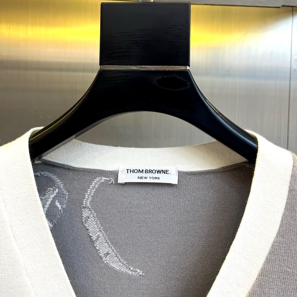 TB汤姆布朗、2025秋冬新品羊毛🦙针织开衫，以灰白拼接设计演绎童趣时尚美学。V领造型搭配黑色纽扣开合，