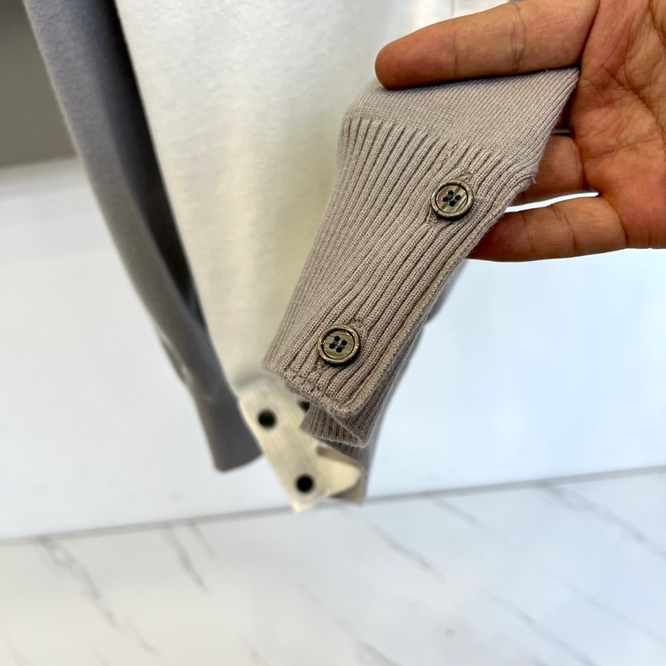 TB汤姆布朗、2025秋冬新品羊毛🦙针织开衫，以灰白拼接设计演绎童趣时尚美学。V领造型搭配黑色纽扣开合，