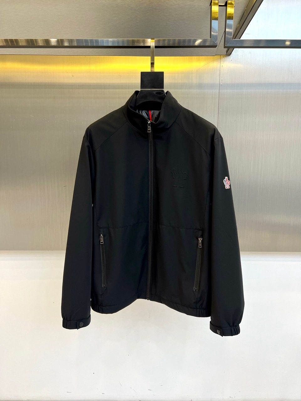 Mon蒙口、2025秋冬新品薄棉机能夹克，以极致纯黑重塑都市未来美学。采用高科技微光感面料打造立体廓形，