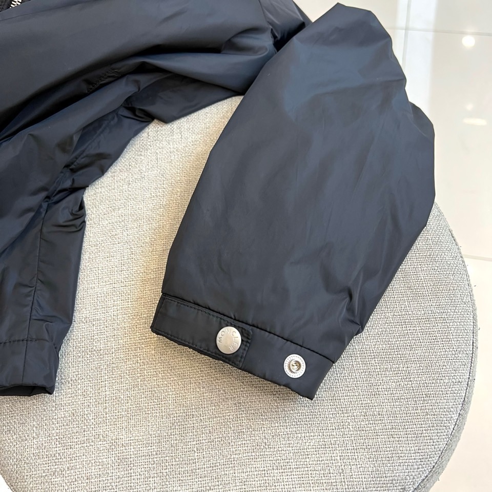 Mon蒙口、25s秋冬新品连帽夹克。冷调纯白如阿尔卑斯新雪，金属背景的钨丝灯光为衣身镀上暖金。拉开拉链乍