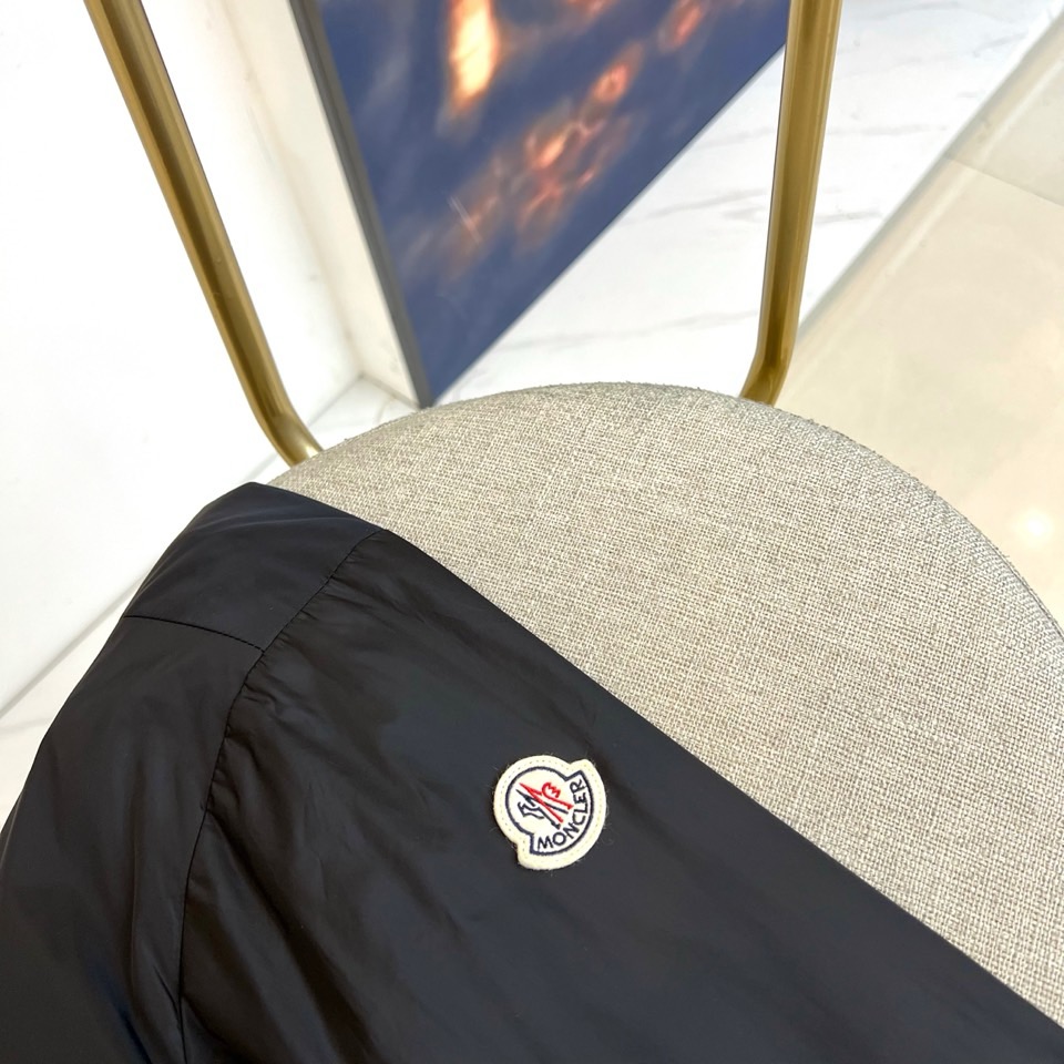 Mon蒙口、25s秋冬新品连帽夹克。冷调纯白如阿尔卑斯新雪，金属背景的钨丝灯光为衣身镀上暖金。拉开拉链乍