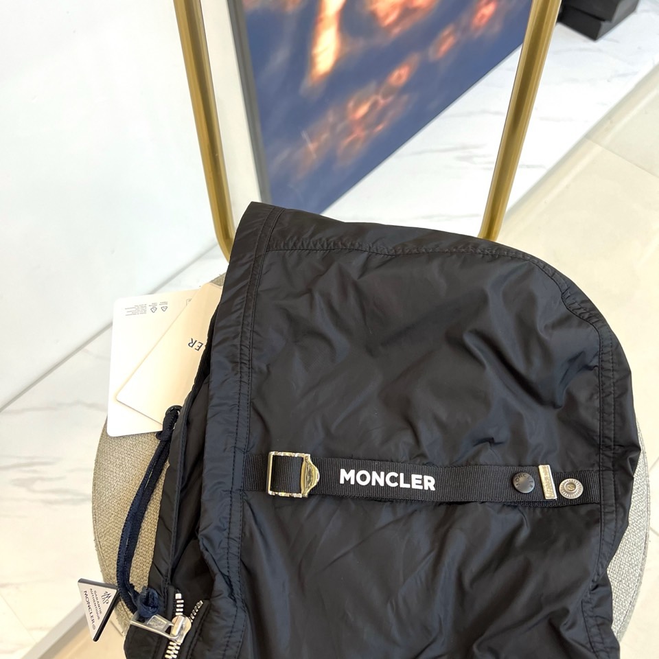 Mon蒙口、25s秋冬新品连帽夹克。冷调纯白如阿尔卑斯新雪，金属背景的钨丝灯光为衣身镀上暖金。拉开拉链乍