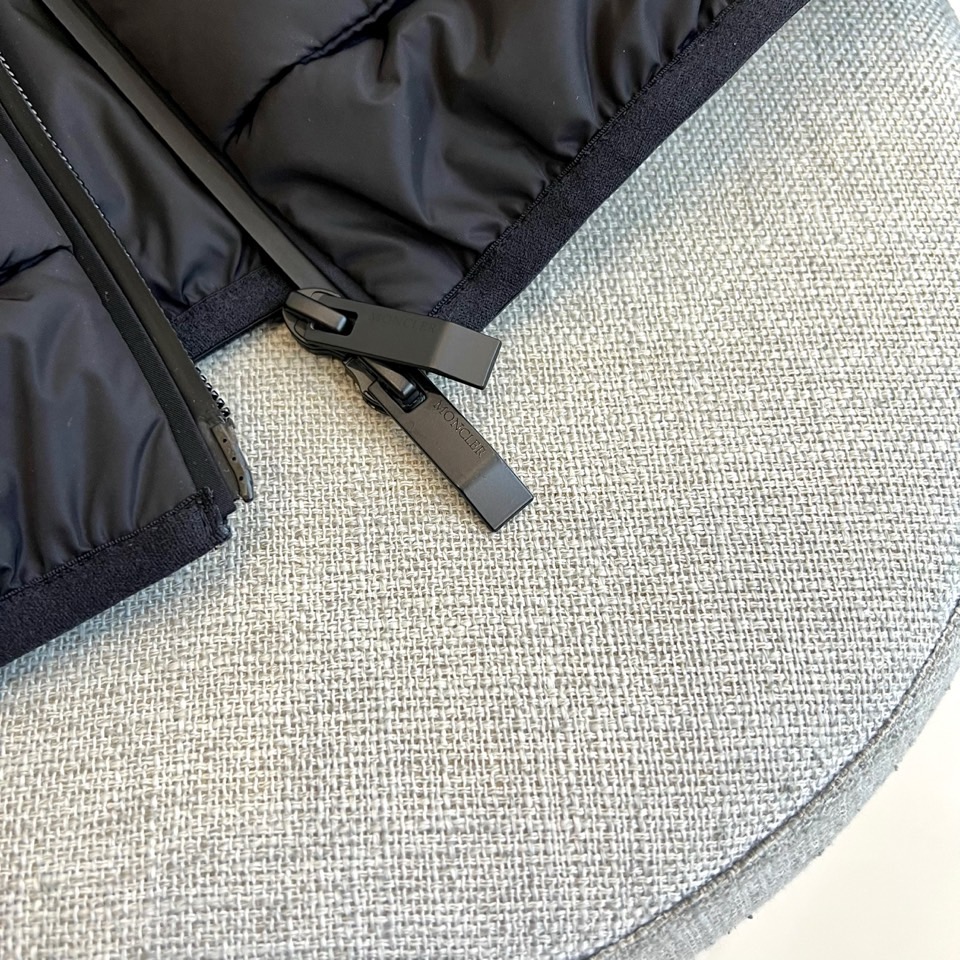 Mon蒙口（鹅绒）、2025秋冬新品，蒙口羽绒马甲，以简约设计诠释高级质感。黑色连帽款式，搭配垂直拉链与